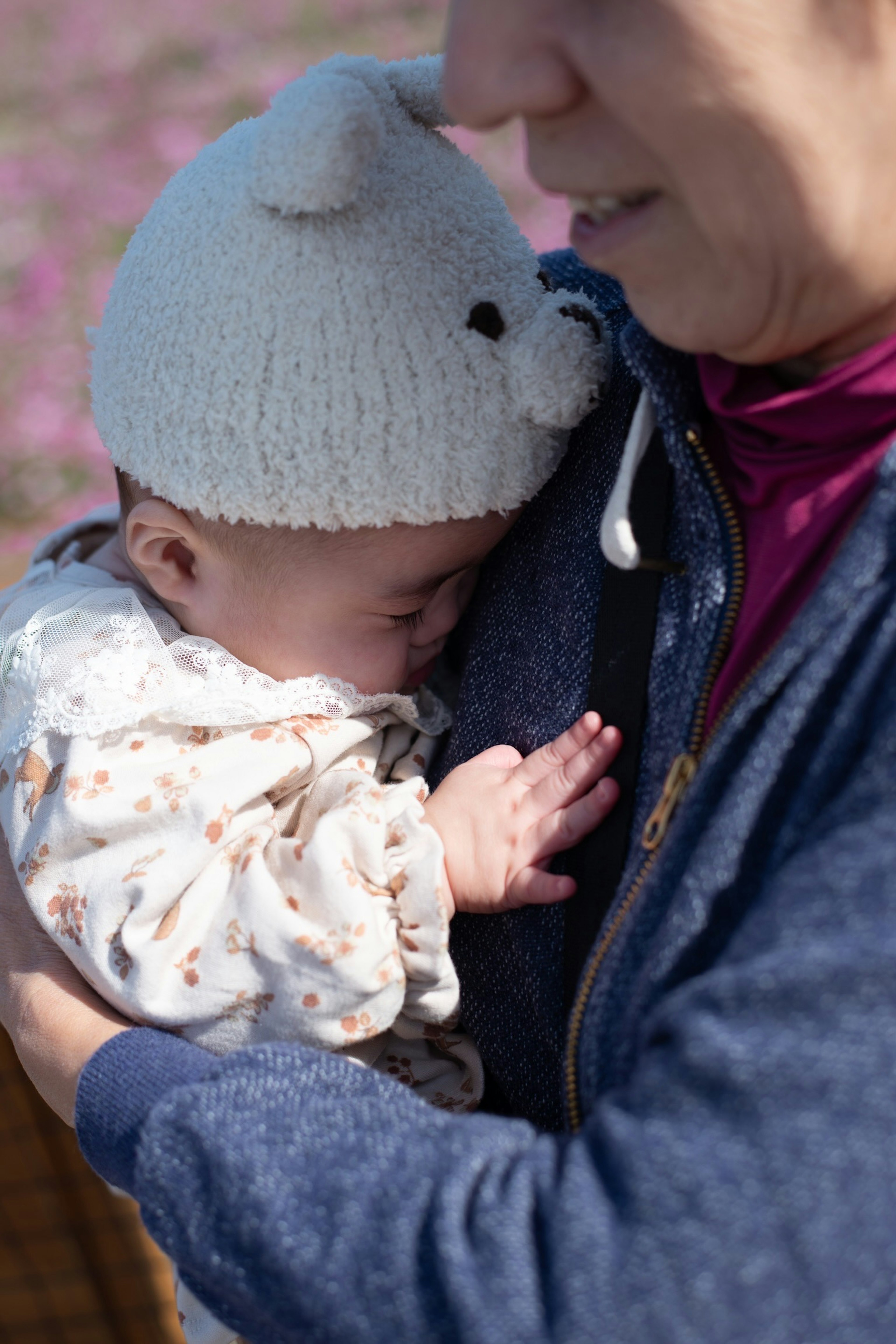 Momento intimo di una donna che tiene un bambino, il bambino indossa un cappello carino e riposa pacificamente