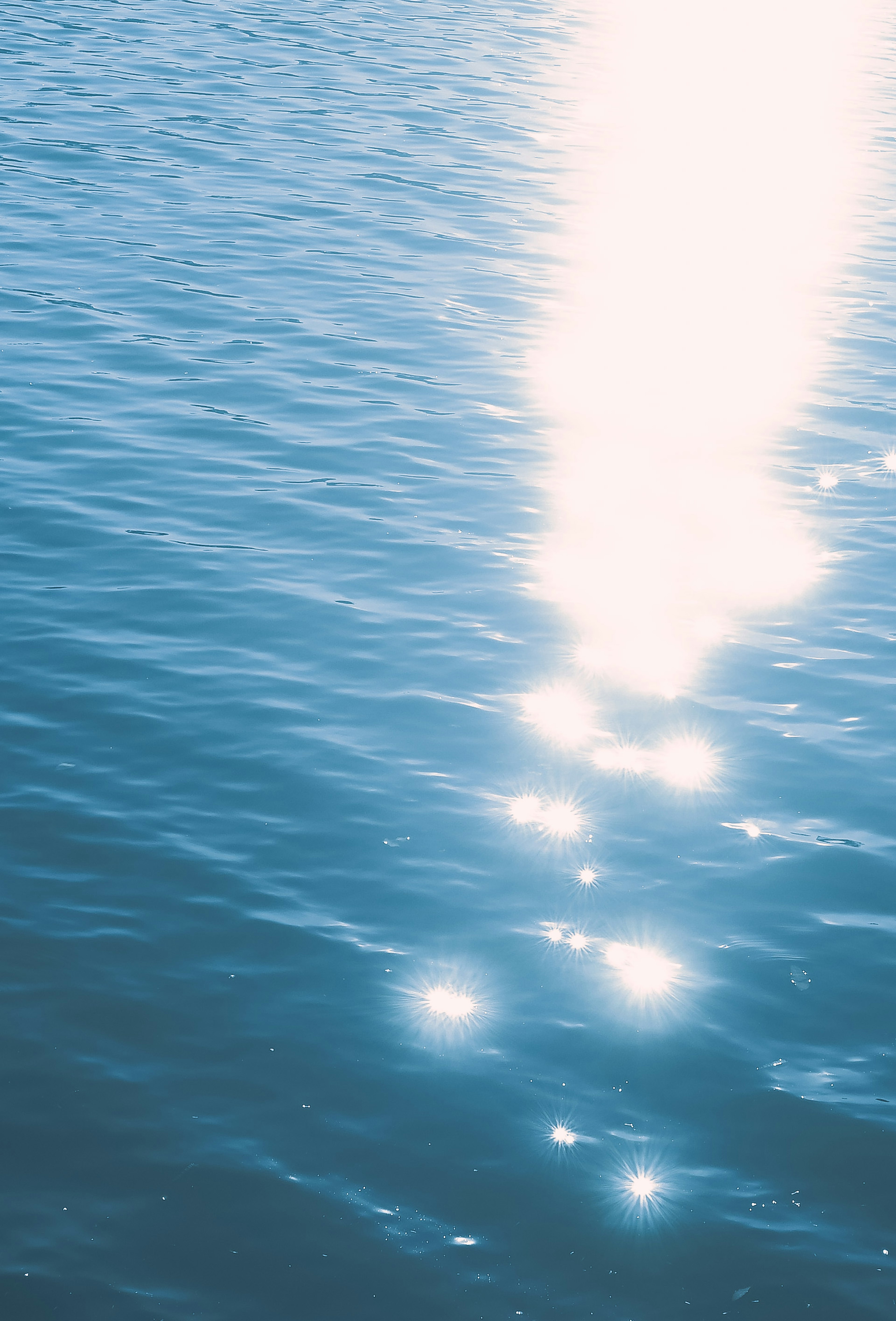 Immagine di una superficie d'acqua blu con riflessi di punti di luce