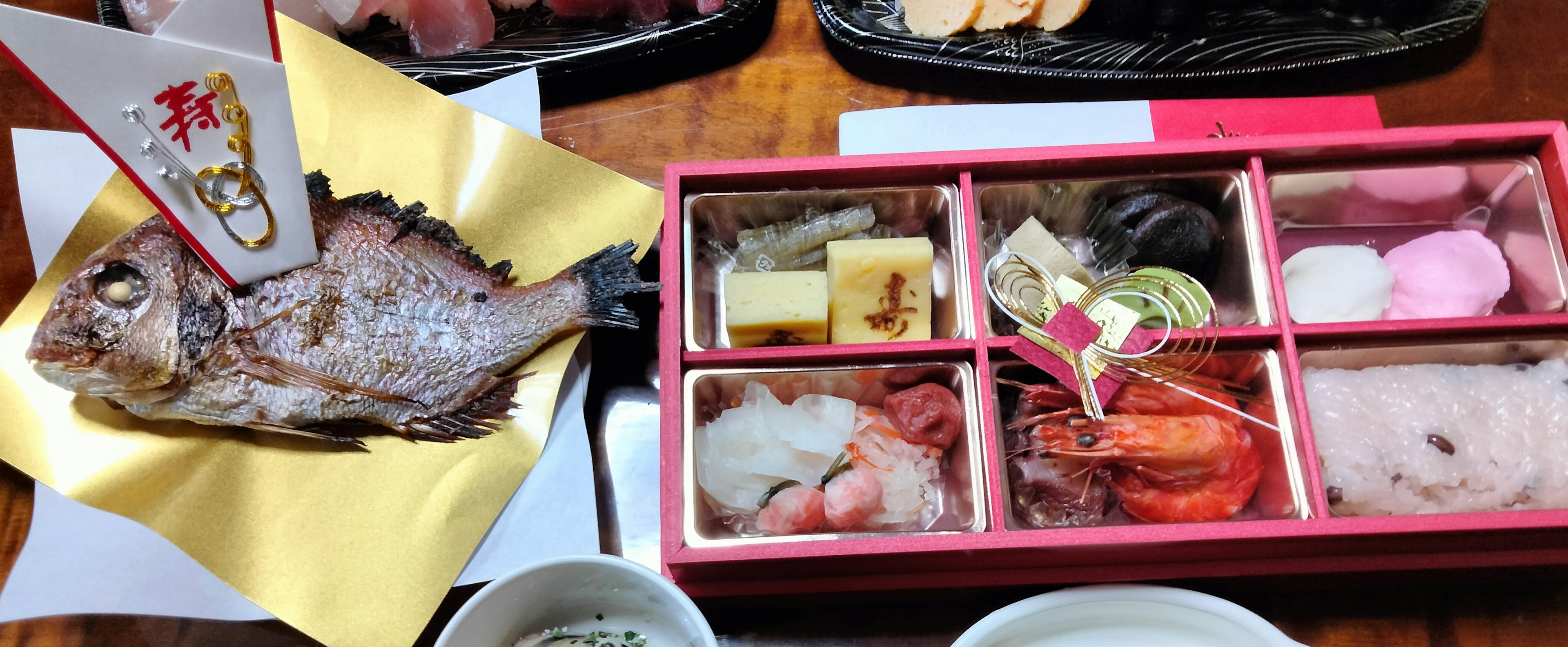 Poisson grillé et sushi colorés disposés sur un plateau japonais traditionnel