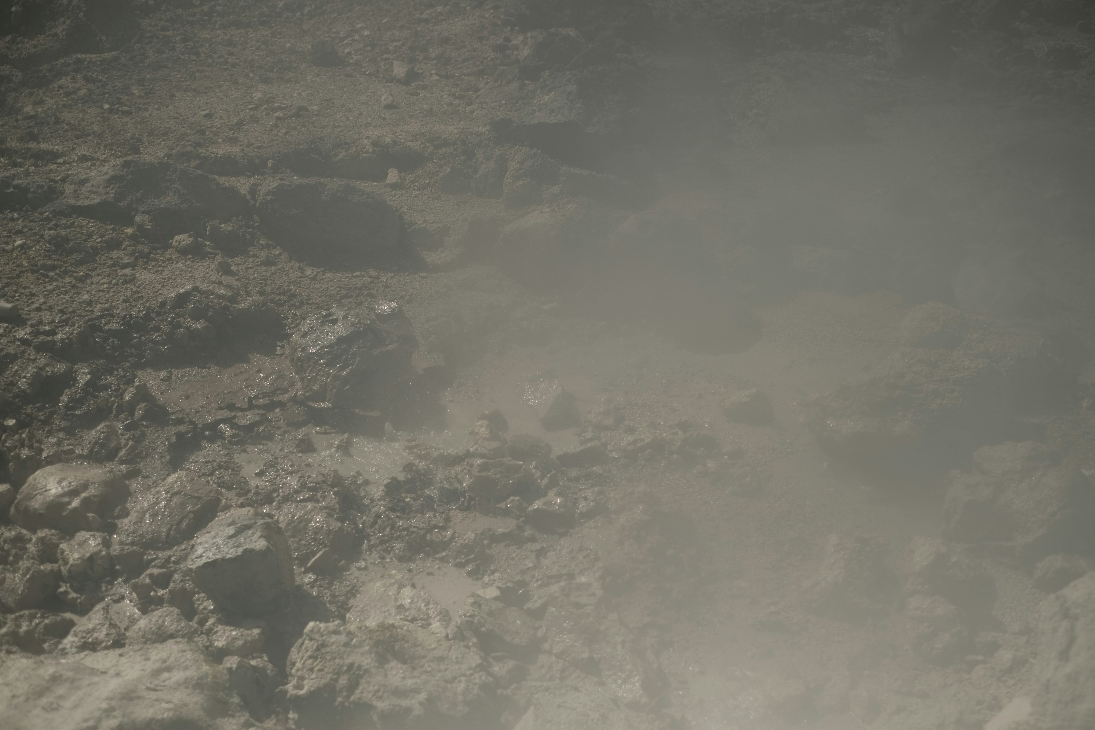 Un paysage brumeux avec des rochers et de la vapeur dans un cadre tropical