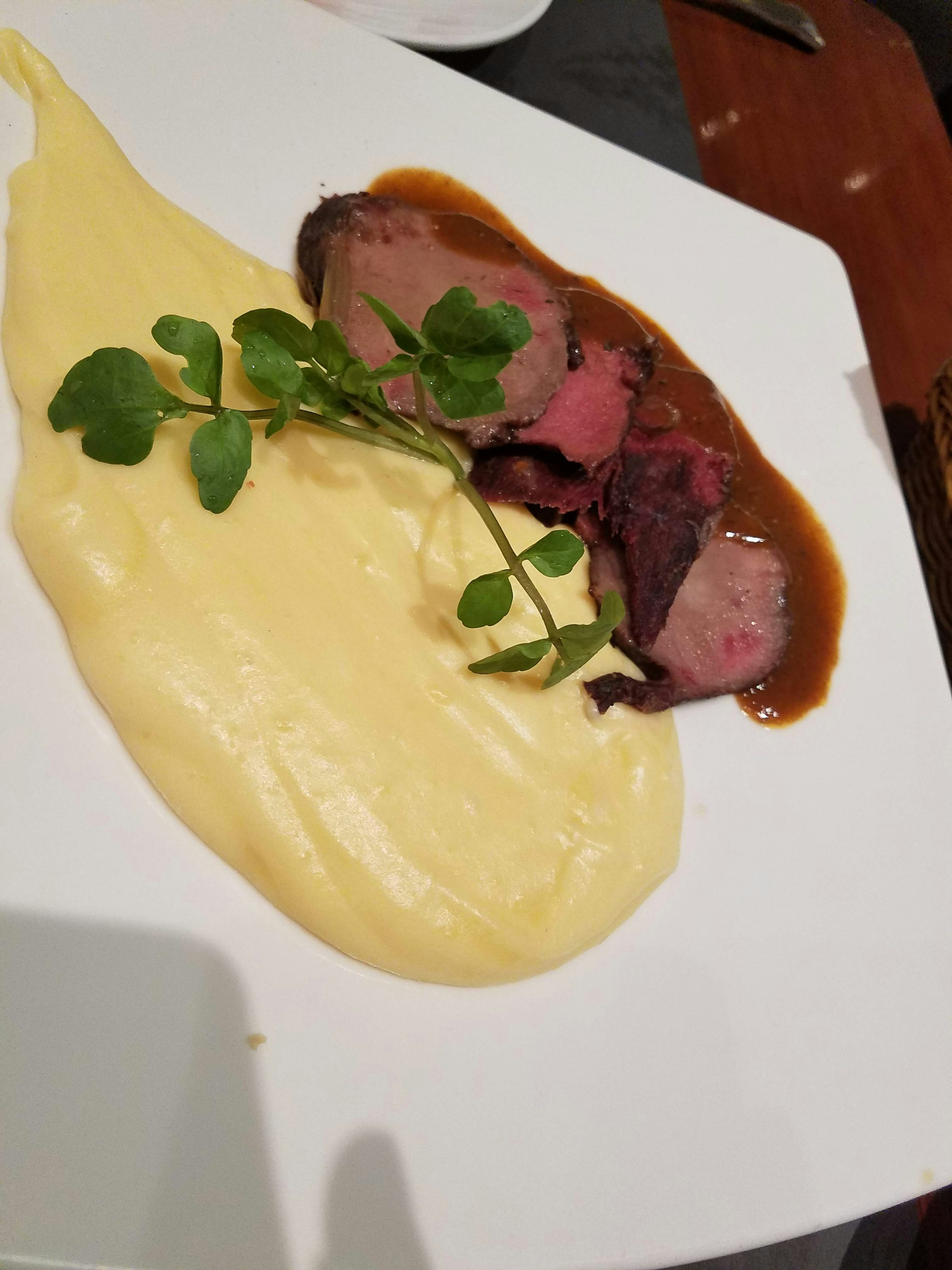 Ein Teller mit cremigem Kartoffelpüree und Rinderbraten mit Sauce