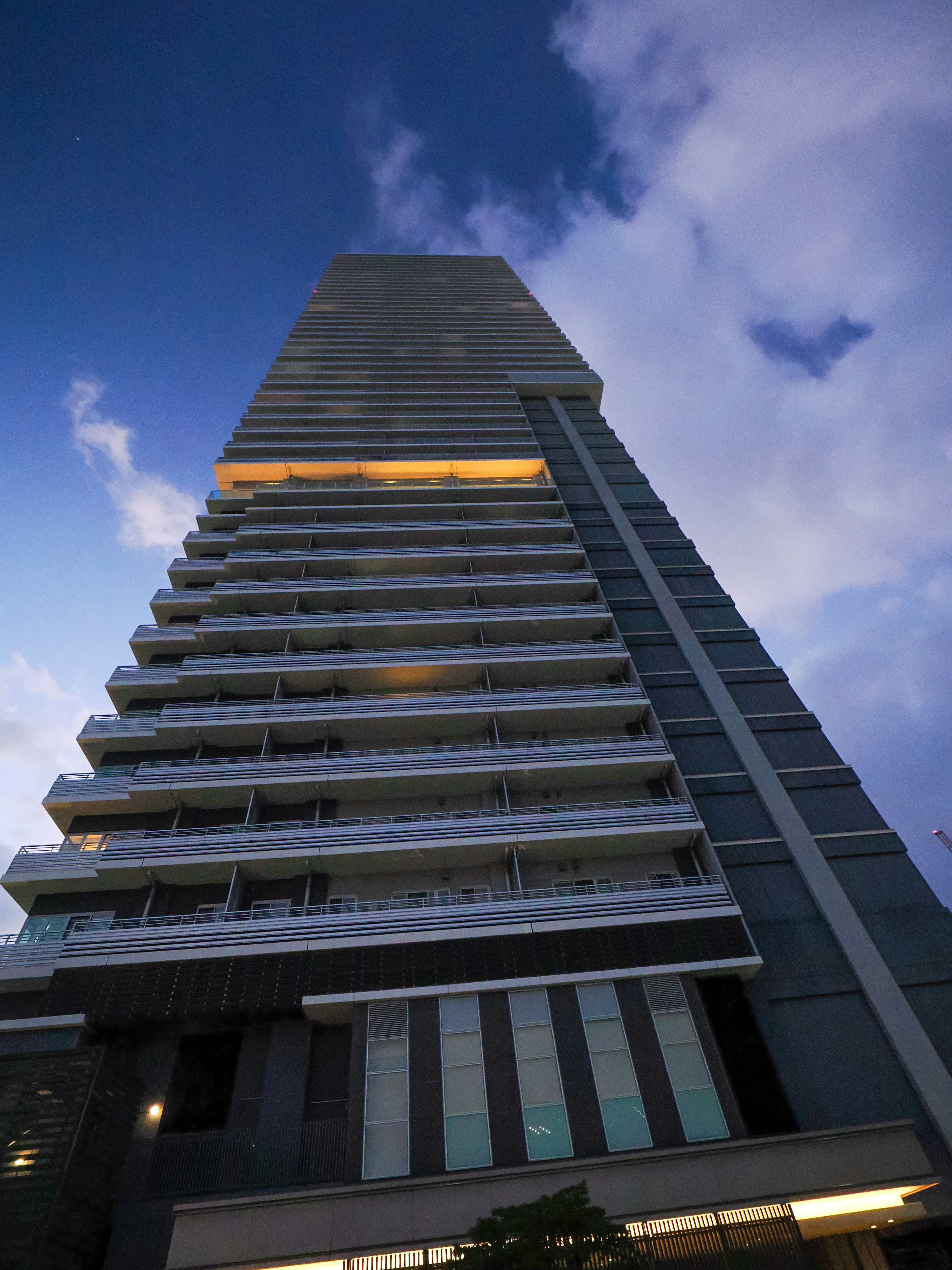 Night view of a high-rise building with a blue sky and clouds in the background