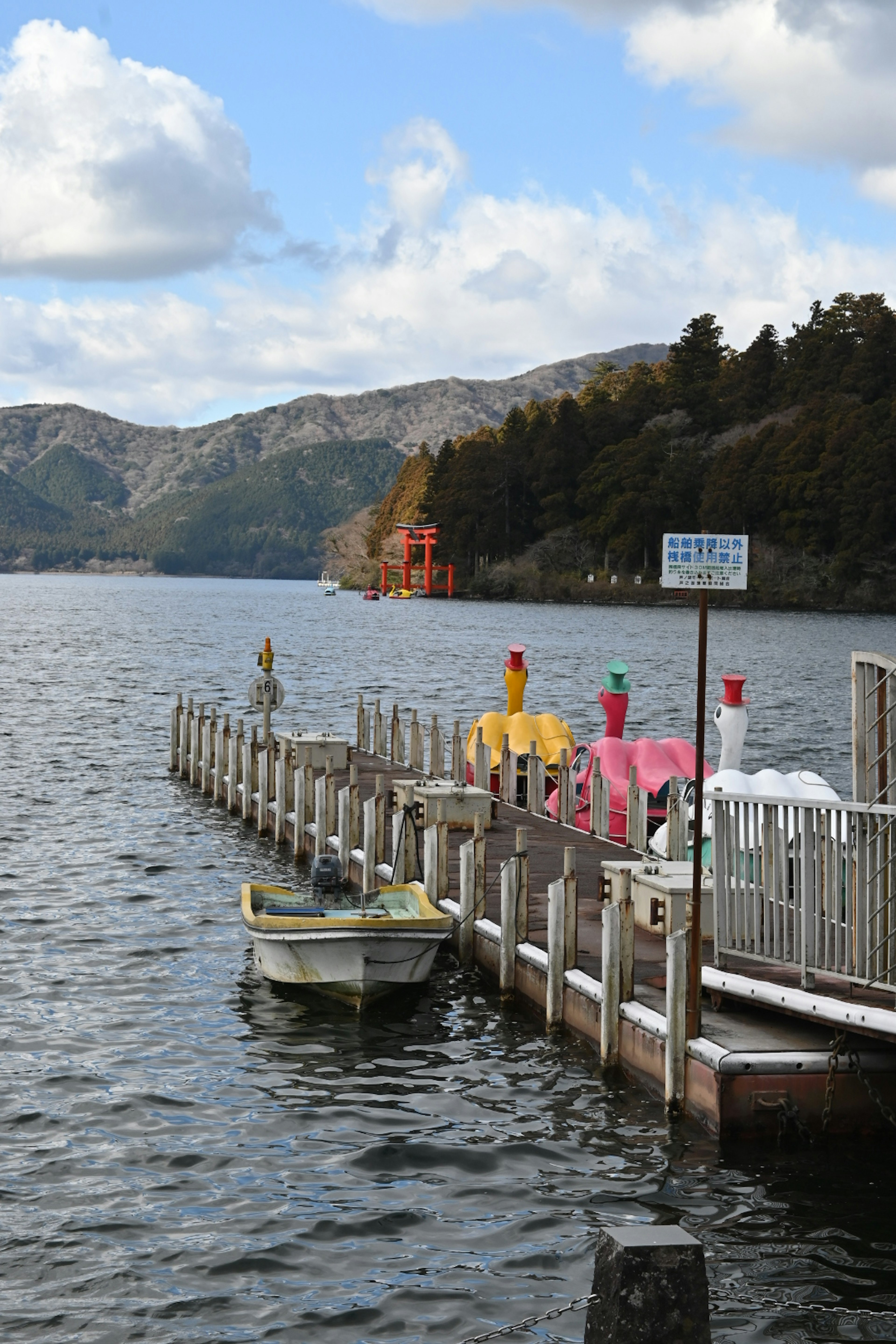 湖に浮かぶ小さなボートとカラフルな傘がある桟橋の風景