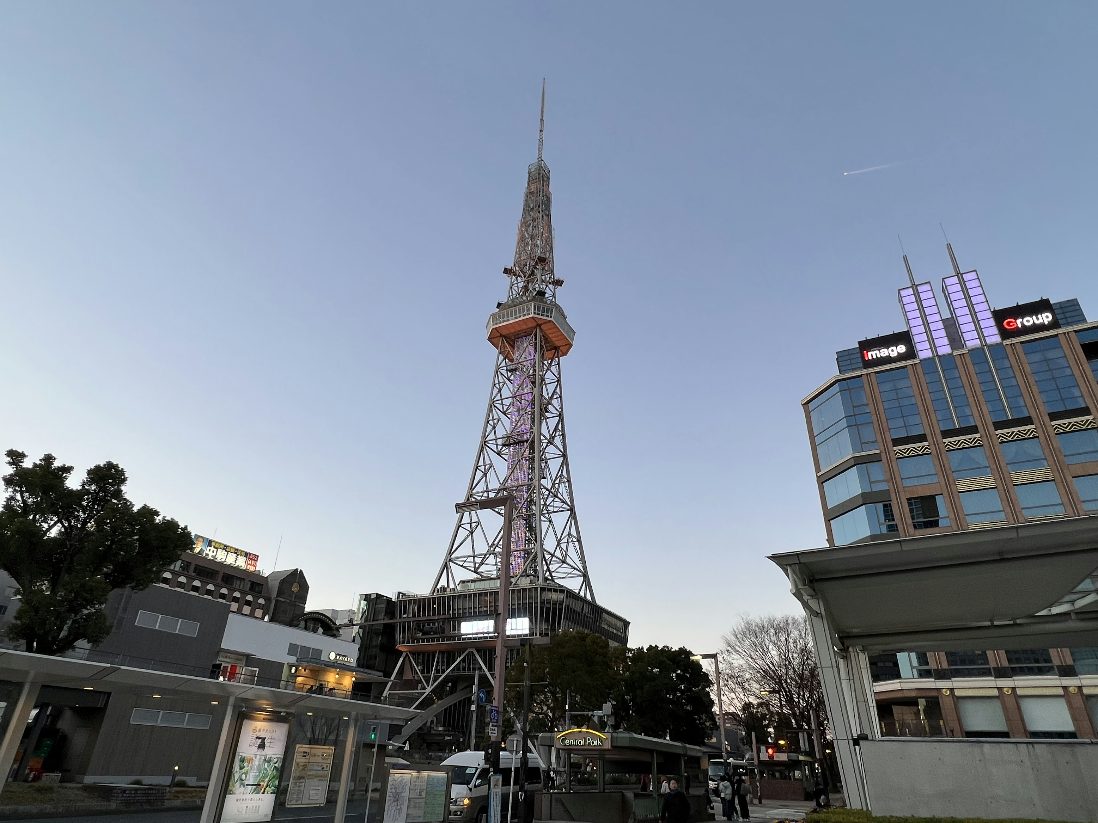 Nagoya Fernsehturm in der Dämmerung mit umliegenden Gebäuden und blauem Himmel