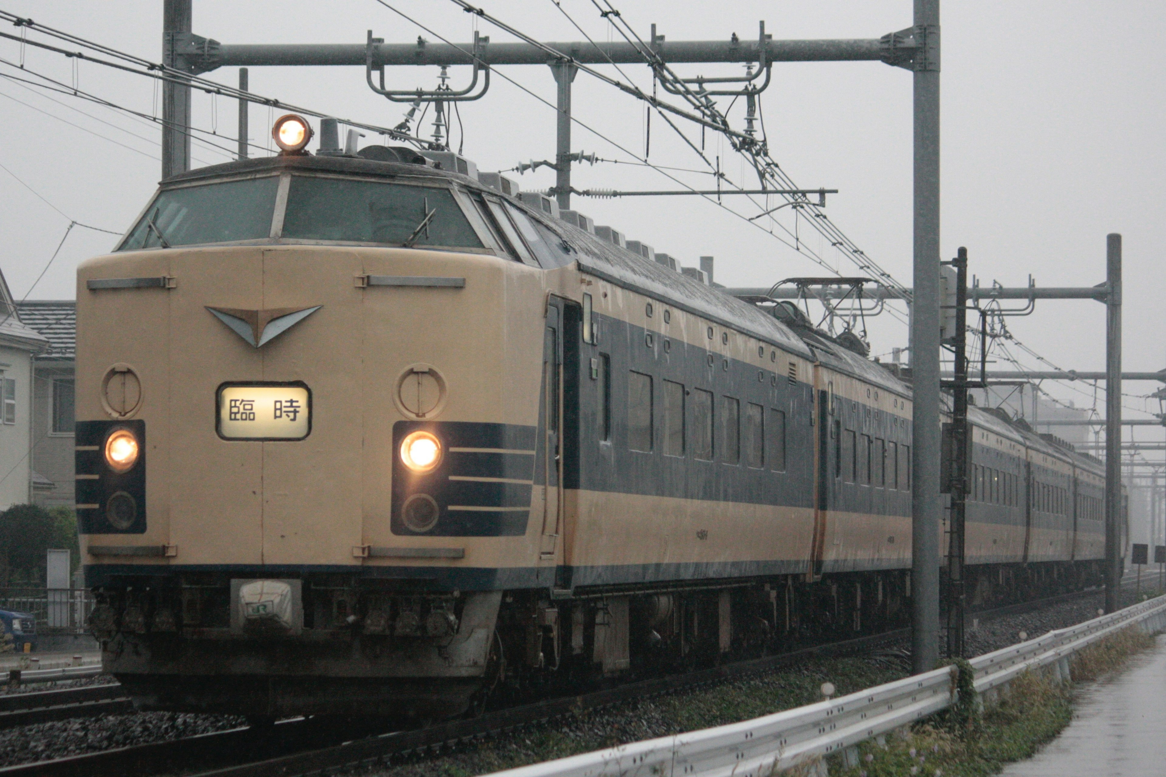 日本の特急列車が雨の中を走行する様子