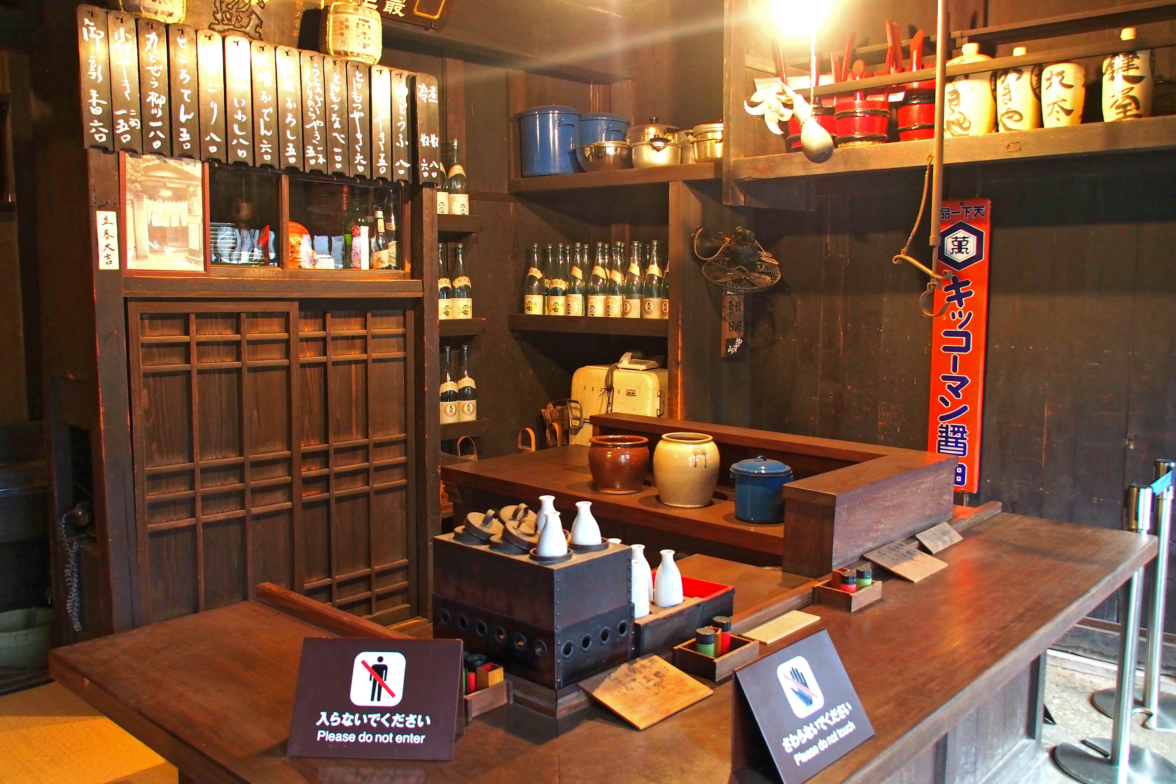 Interior de una tienda de sake japonesa tradicional mostrador de madera y estantes con botellas de sake