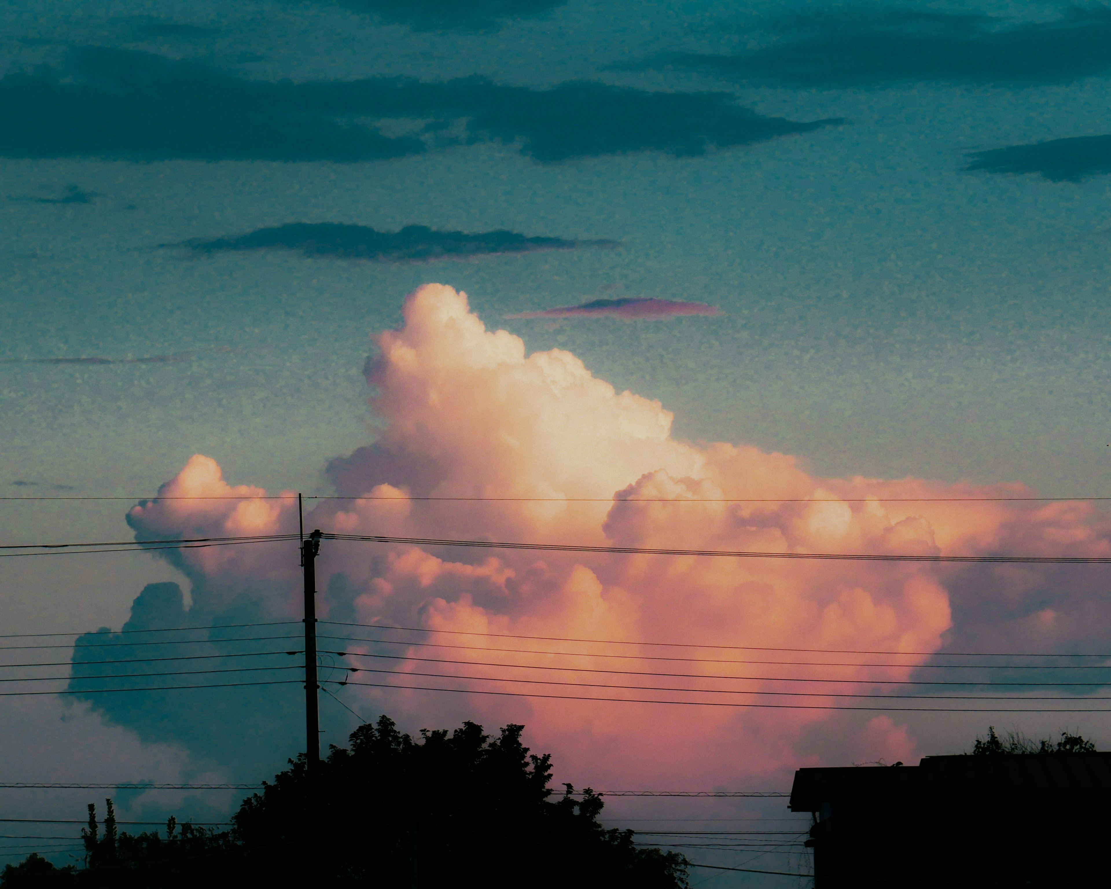 Silhouette awan yang diterangi matahari terbenam dengan kabel listrik