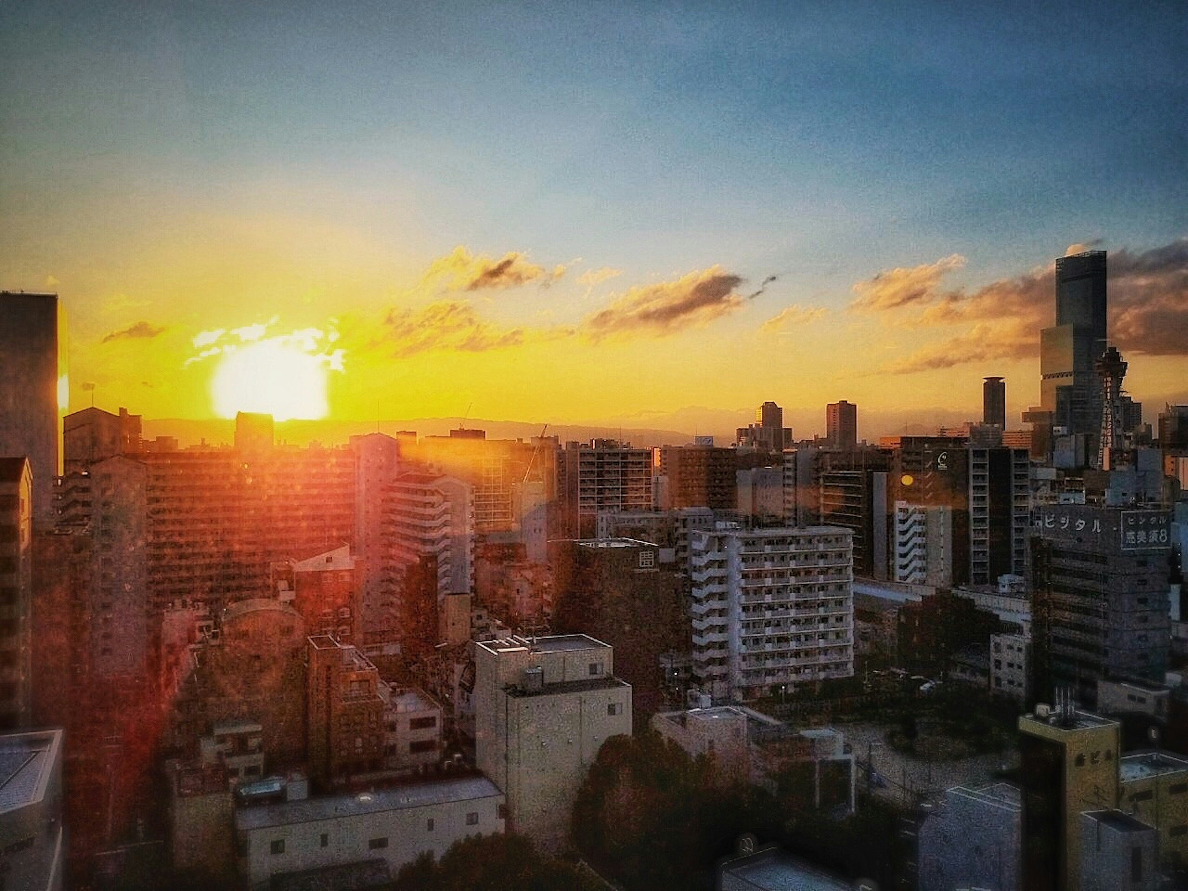 Paisaje urbano al atardecer con edificios altos y áreas residenciales