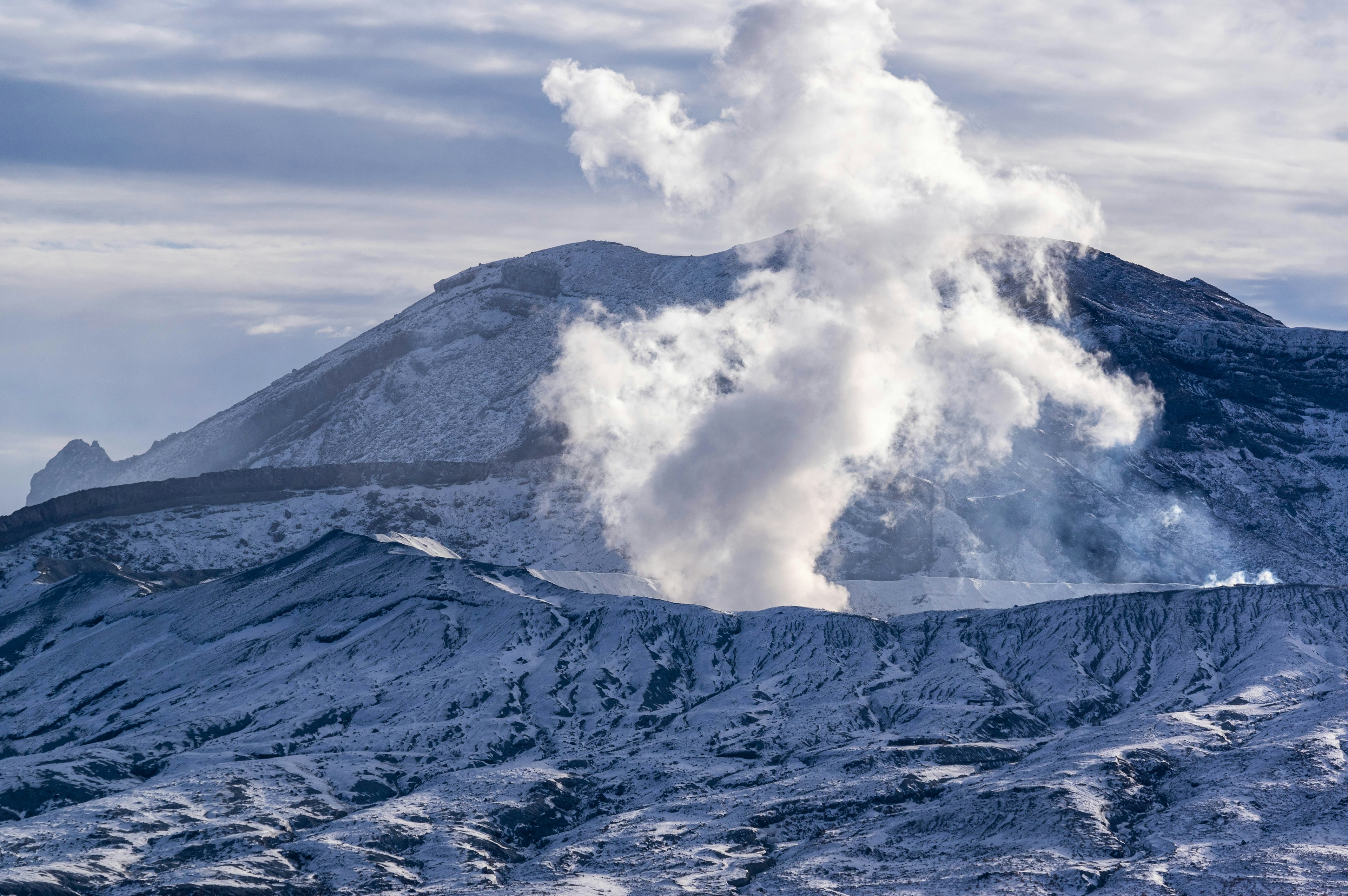 被雪覆盖的山脉和火山烟雾的风景