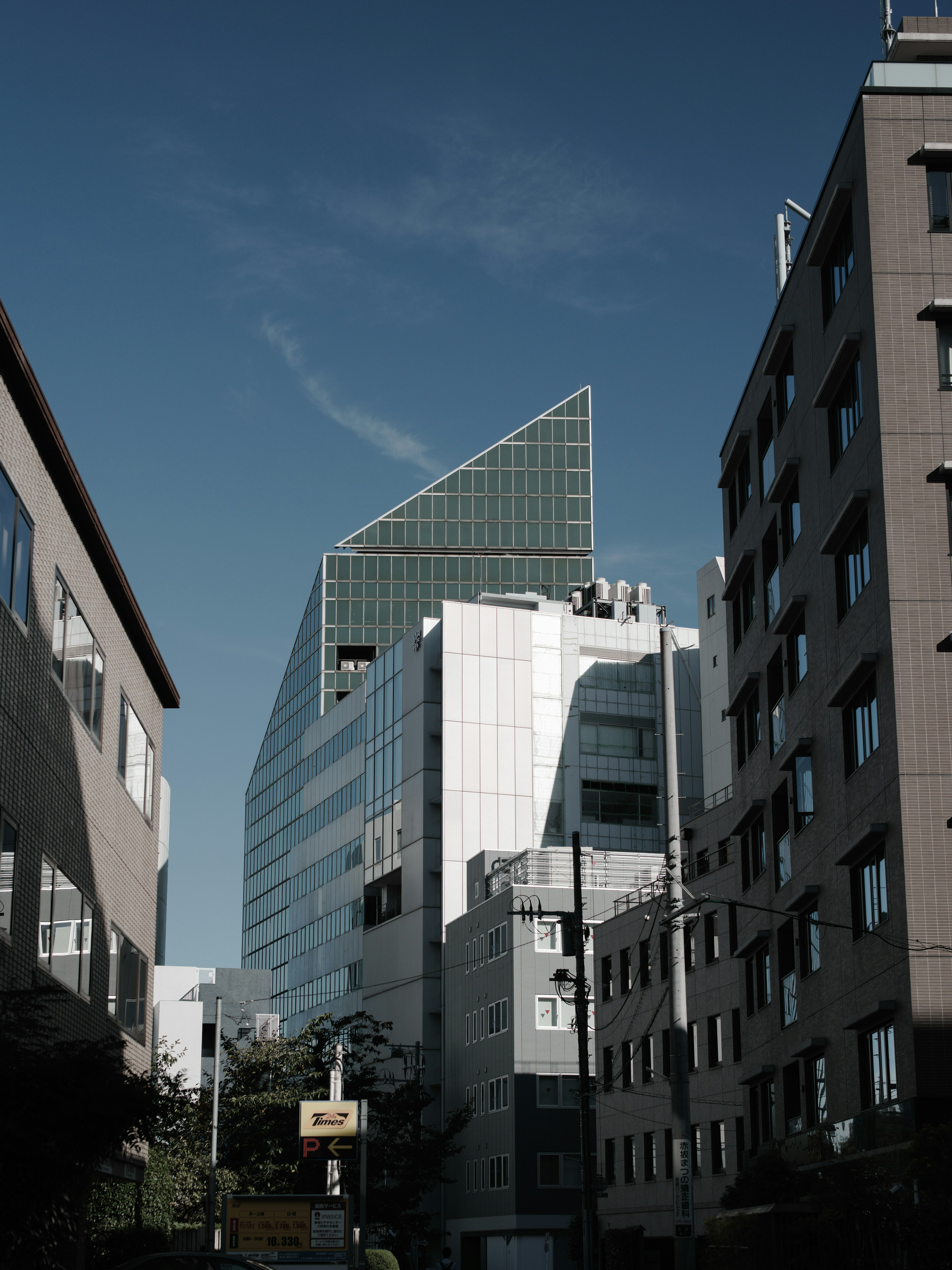 Modern building with a unique triangular design among city structures