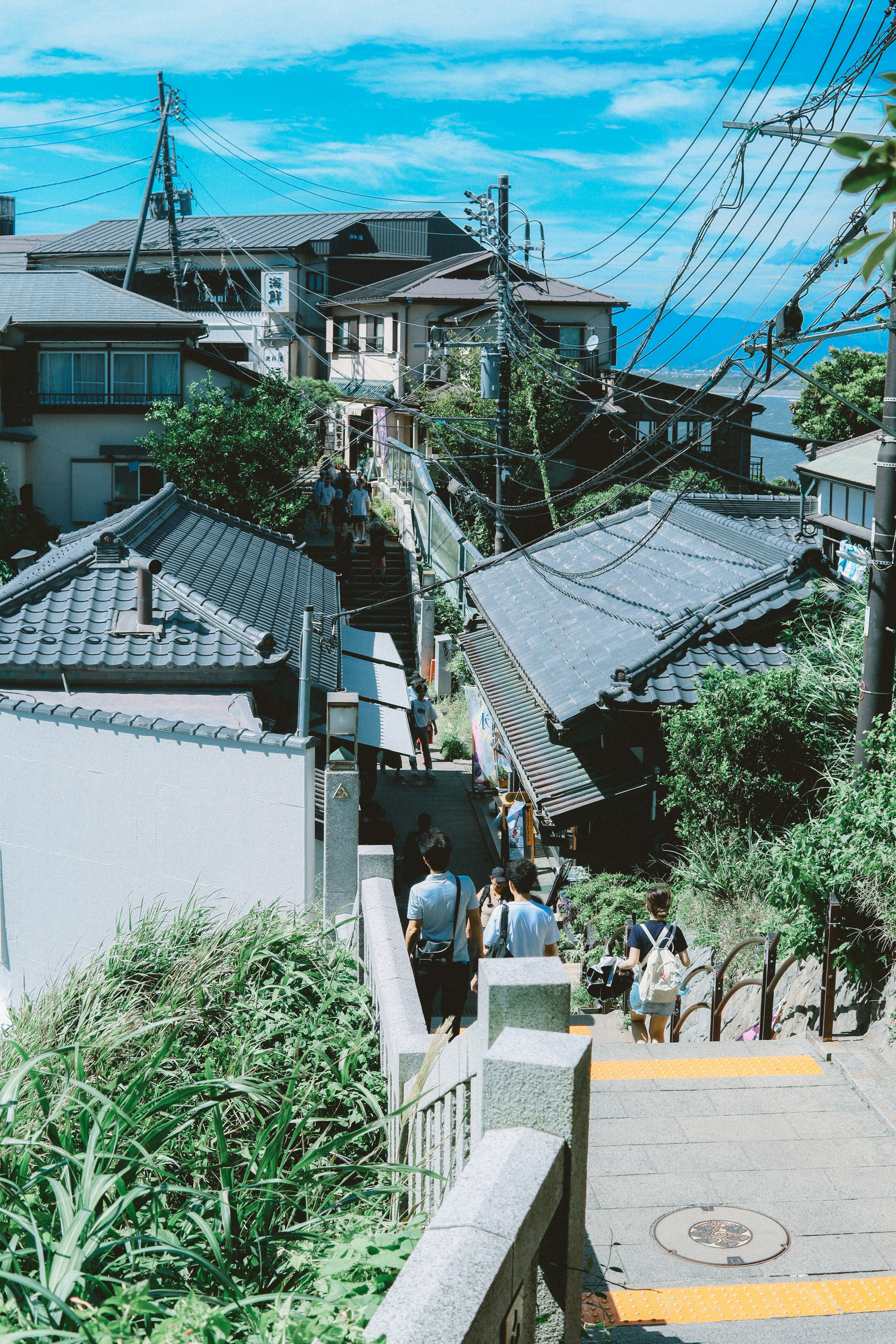 青空の下に広がる古い街並みと人々が歩く階段