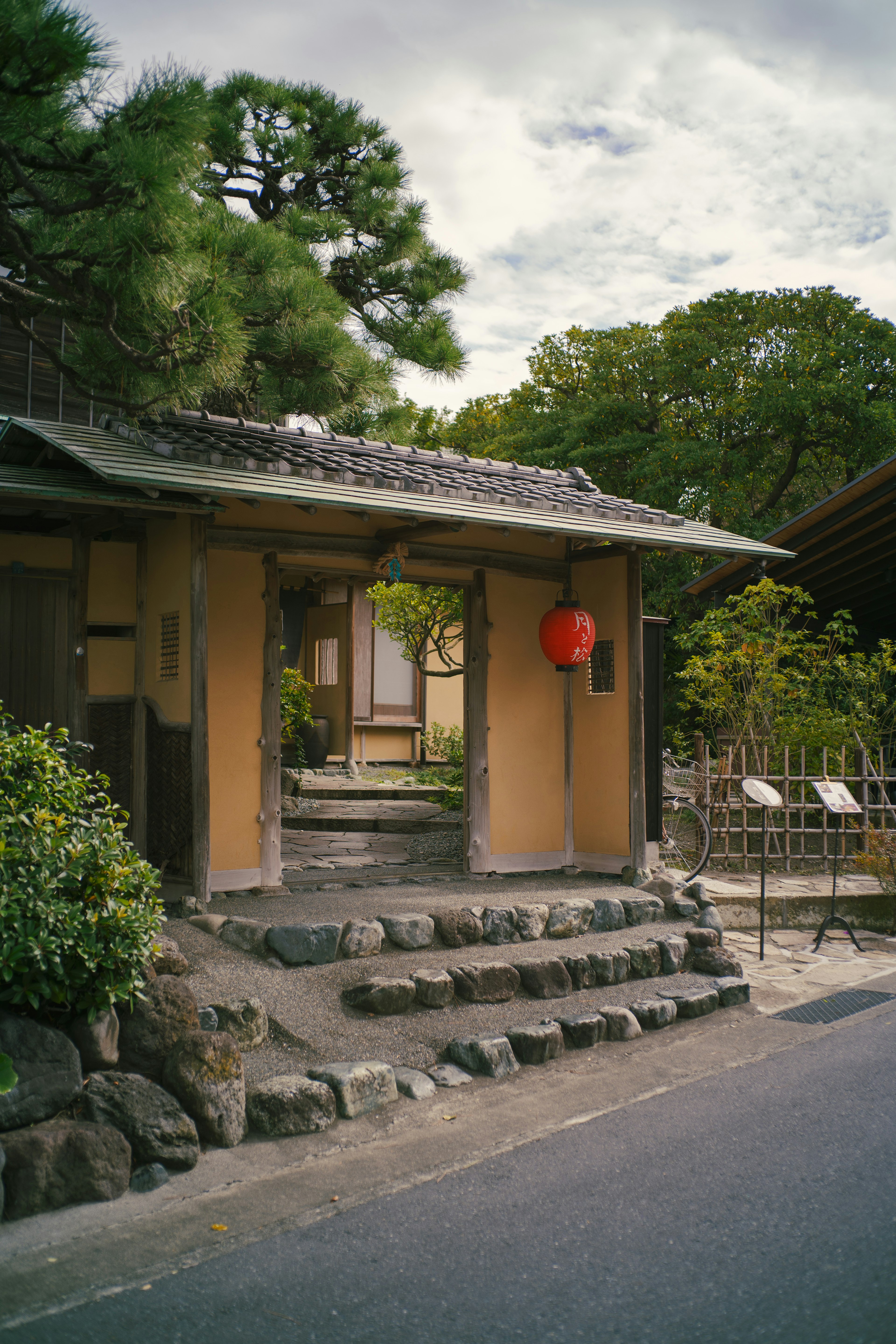 Pintu masuk rumah Jepang tradisional dengan lentera merah dan tangga batu