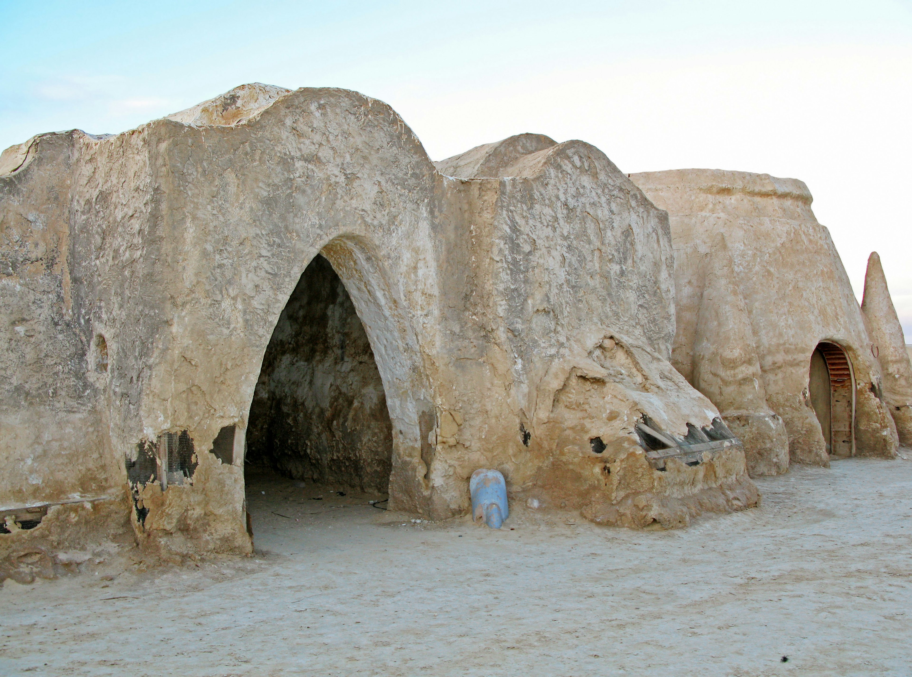 Ruines d'habitations anciennes dans le désert avec des entrées en arc distinctives