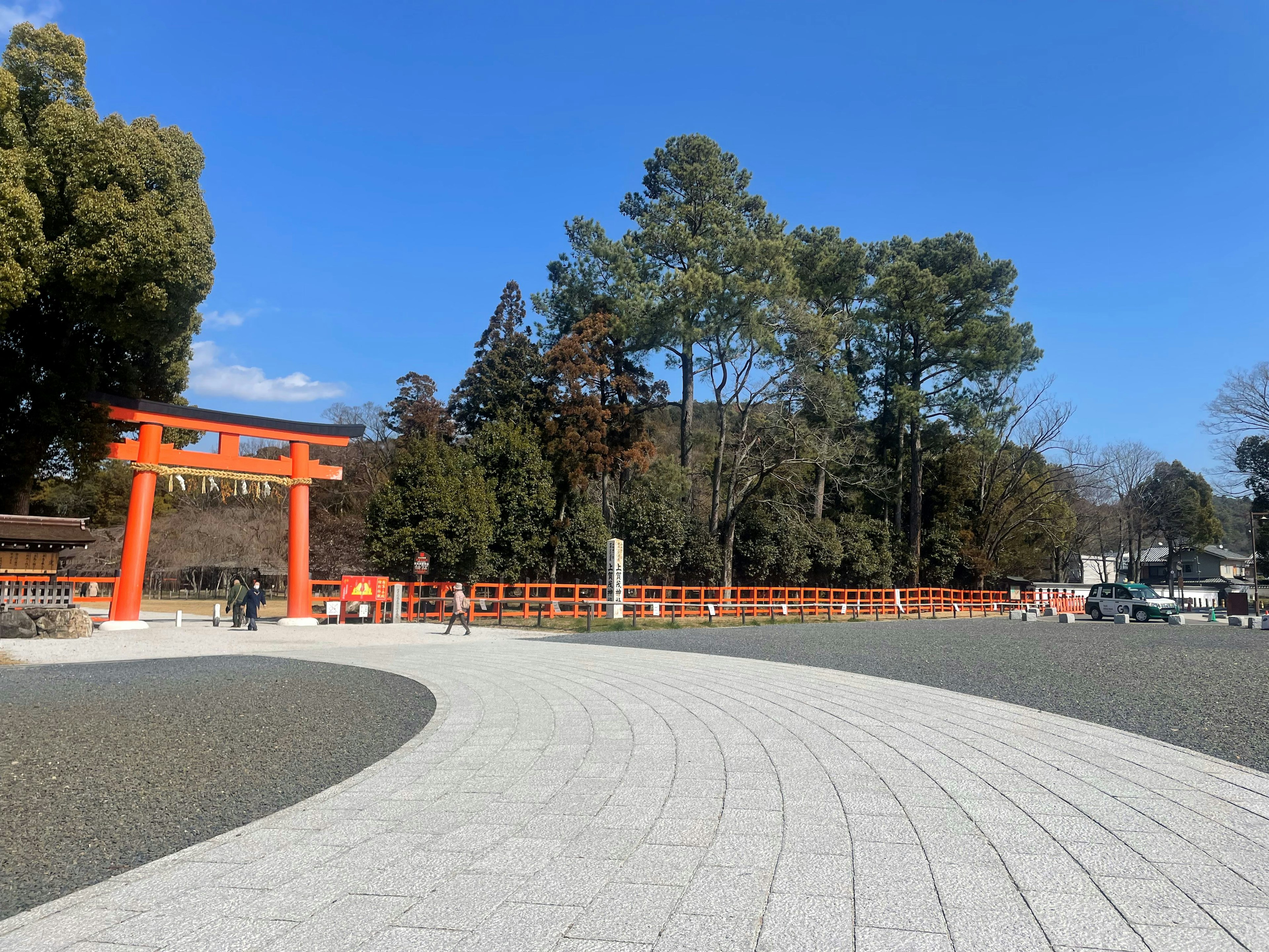 Malersicher Blick auf einen Park mit einem roten Torii und blauem Himmel