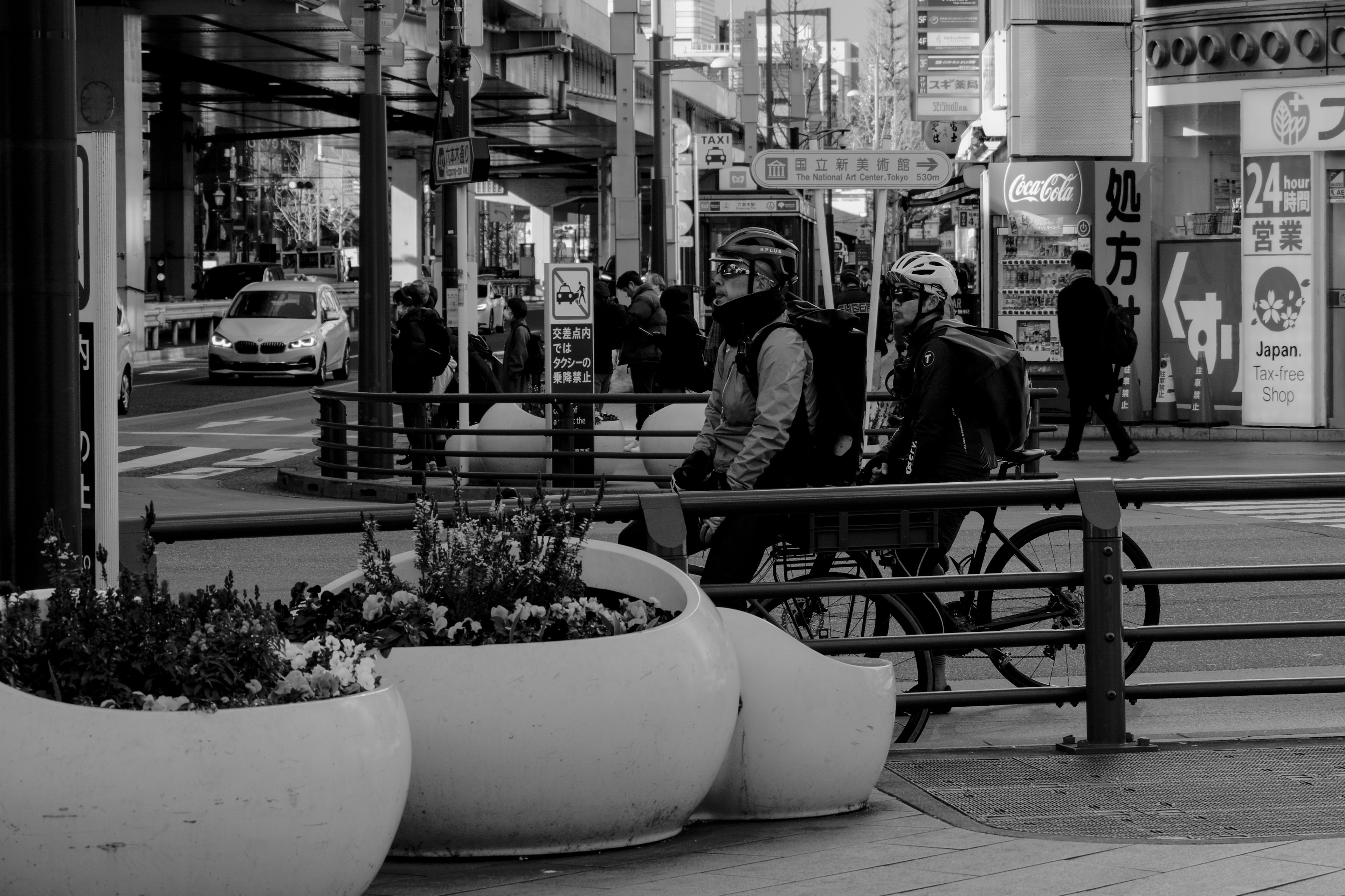 Black and white urban scene featuring two people on a bicycle