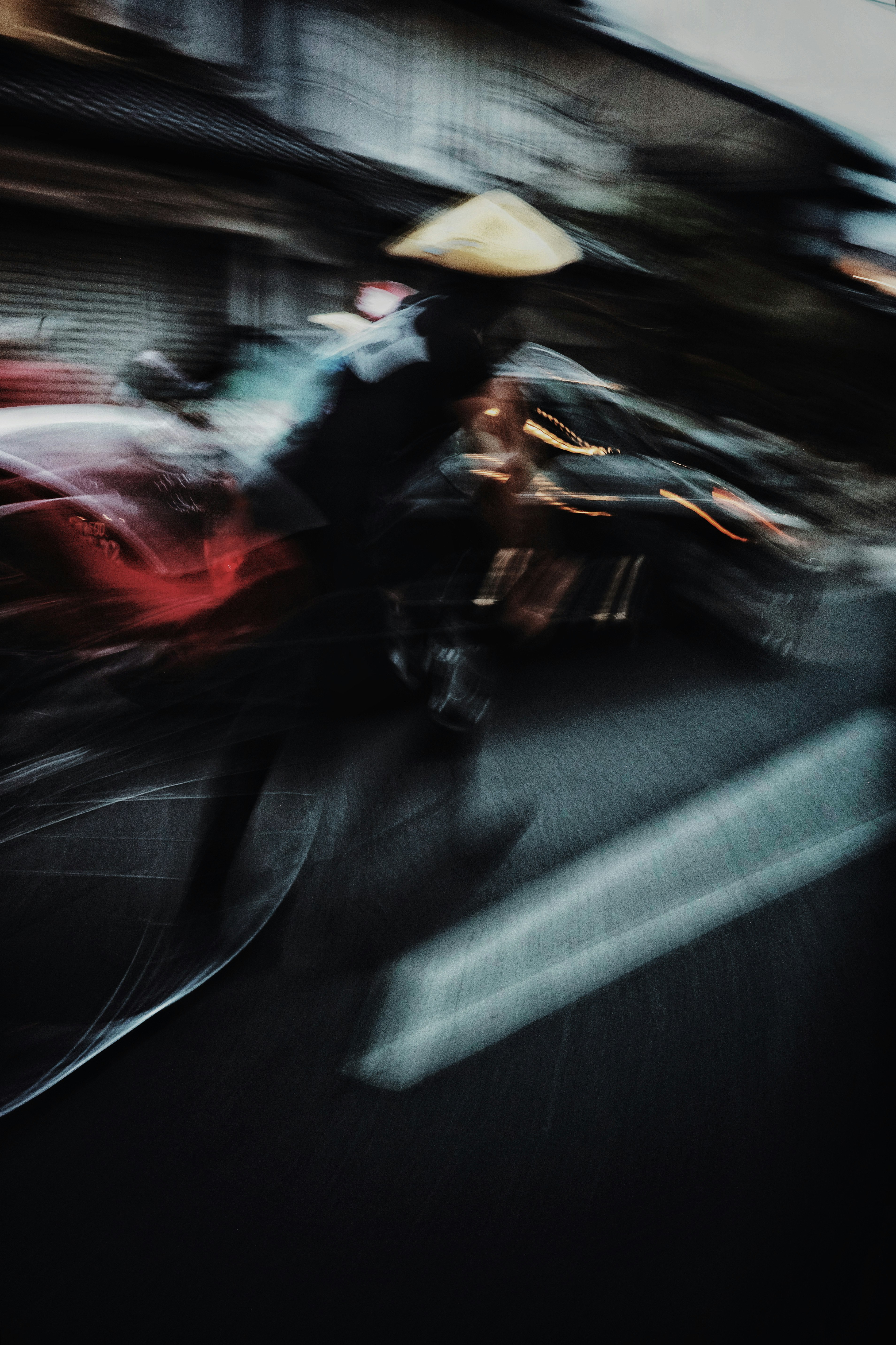 A blurred image of a person riding a bicycle in an Asian street scene