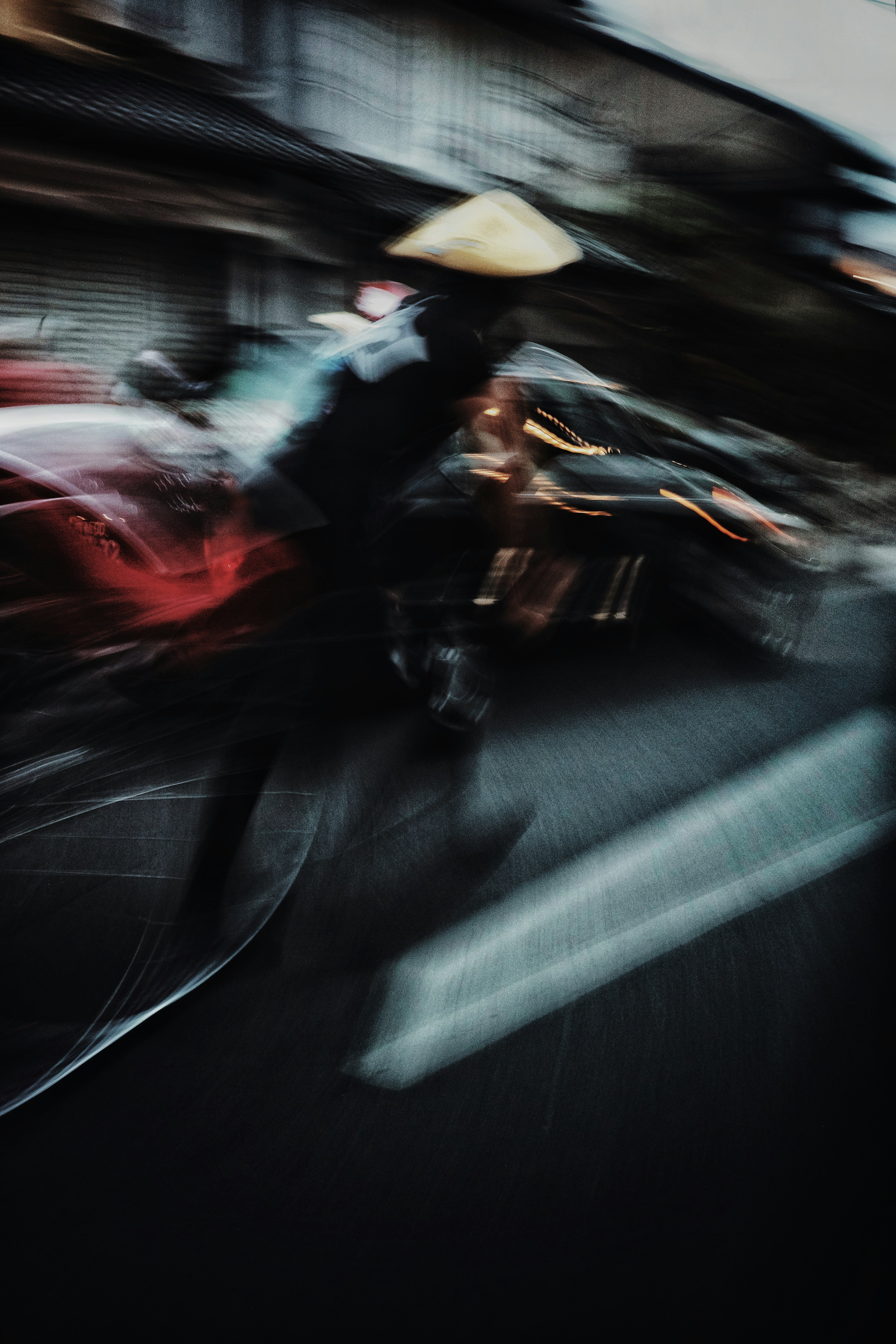 A blurred image of a person riding a bicycle in an Asian street scene