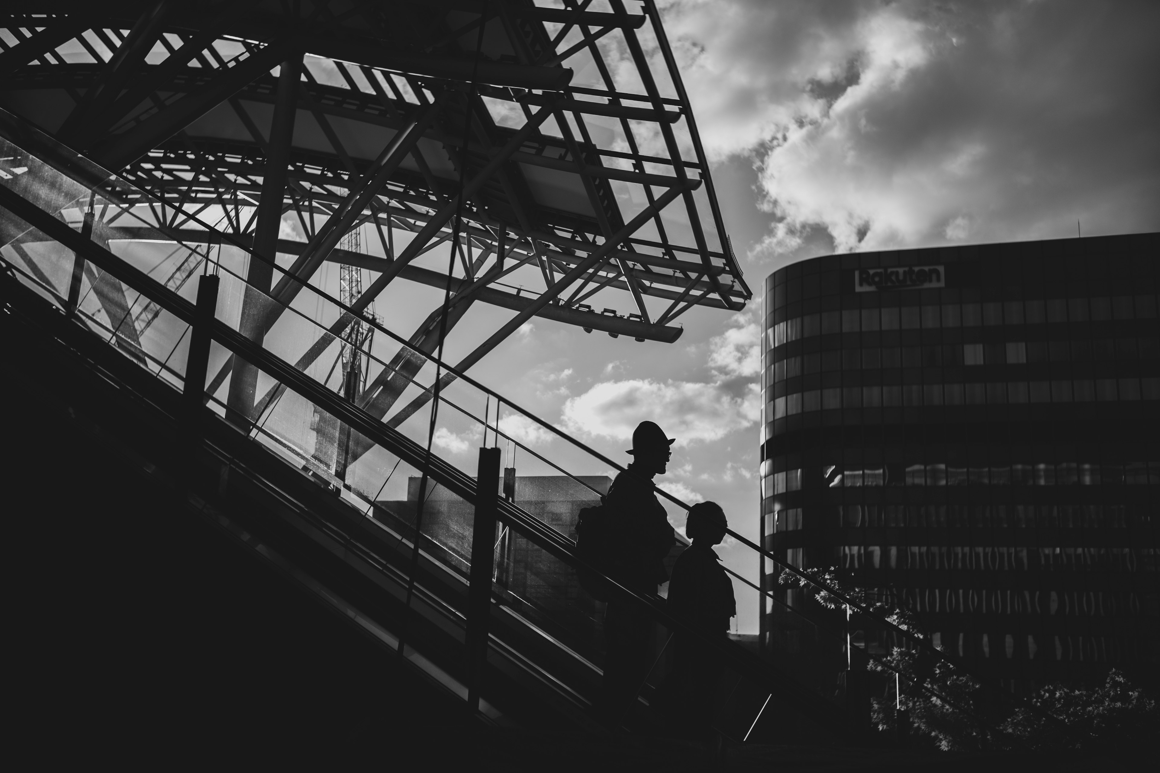 Silhouettes of people ascending stairs with modern buildings in the background