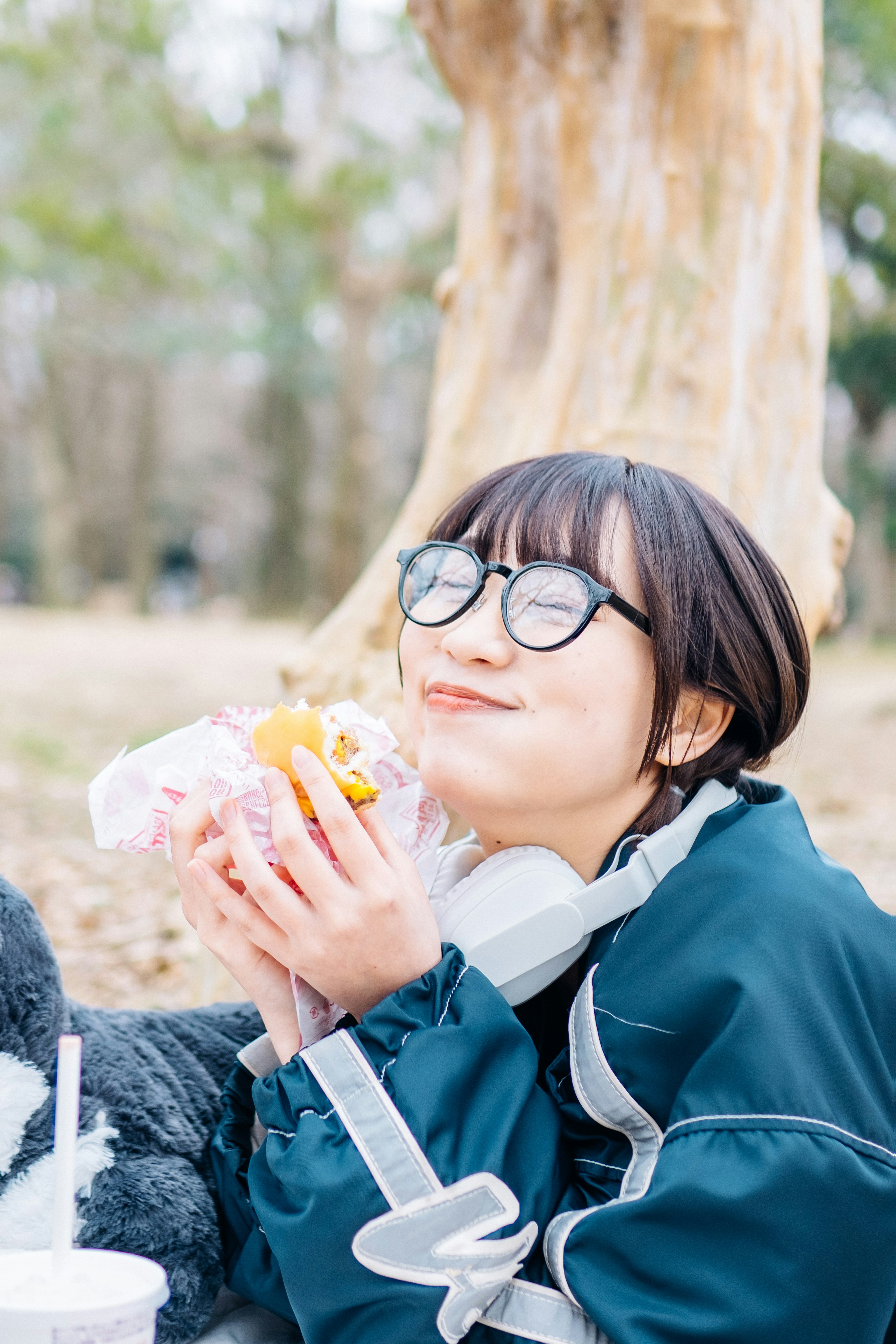 公園で食べ物を持って微笑む女性の写真