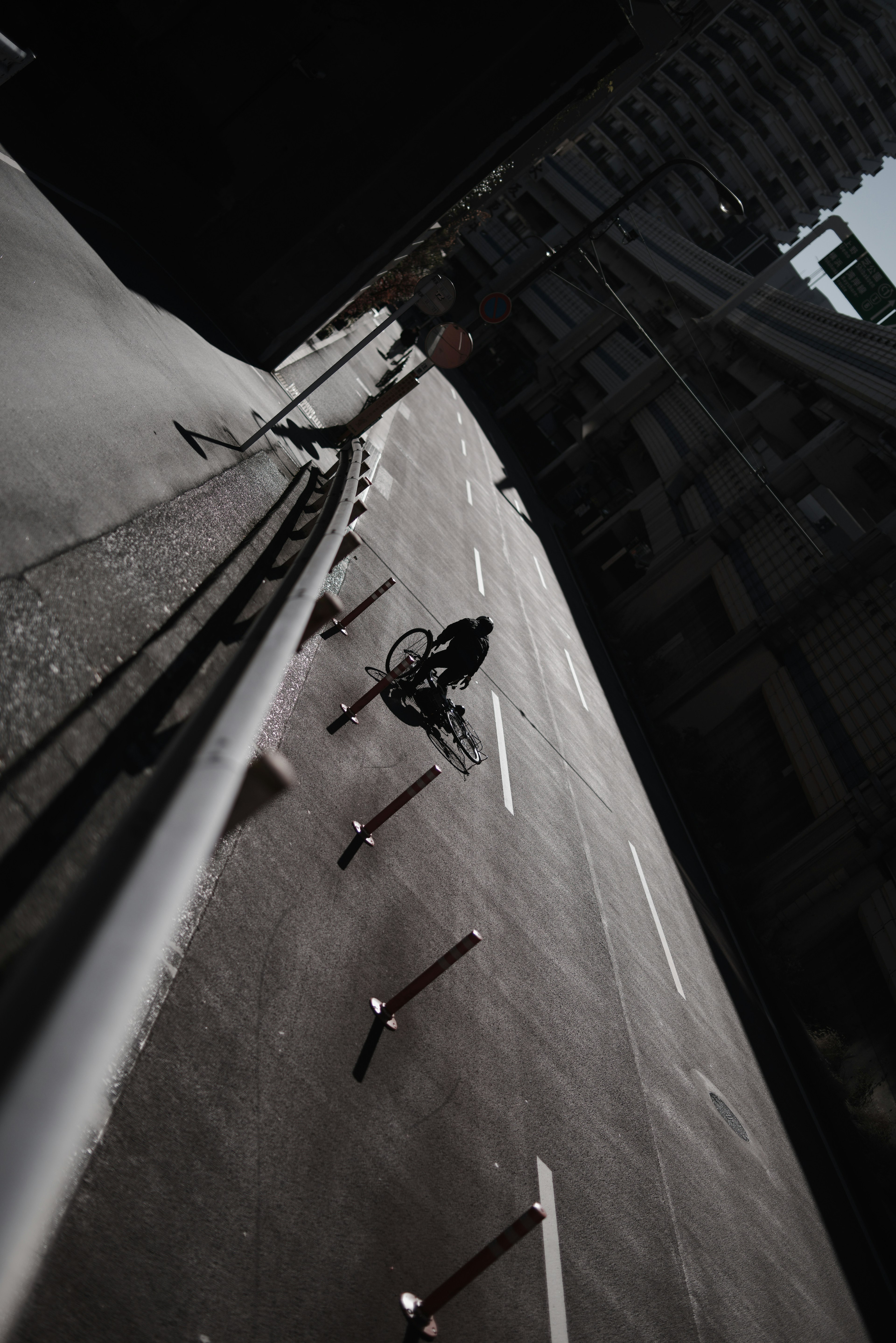 傾斜した道路に自転車に乗った人物がいる都市風景