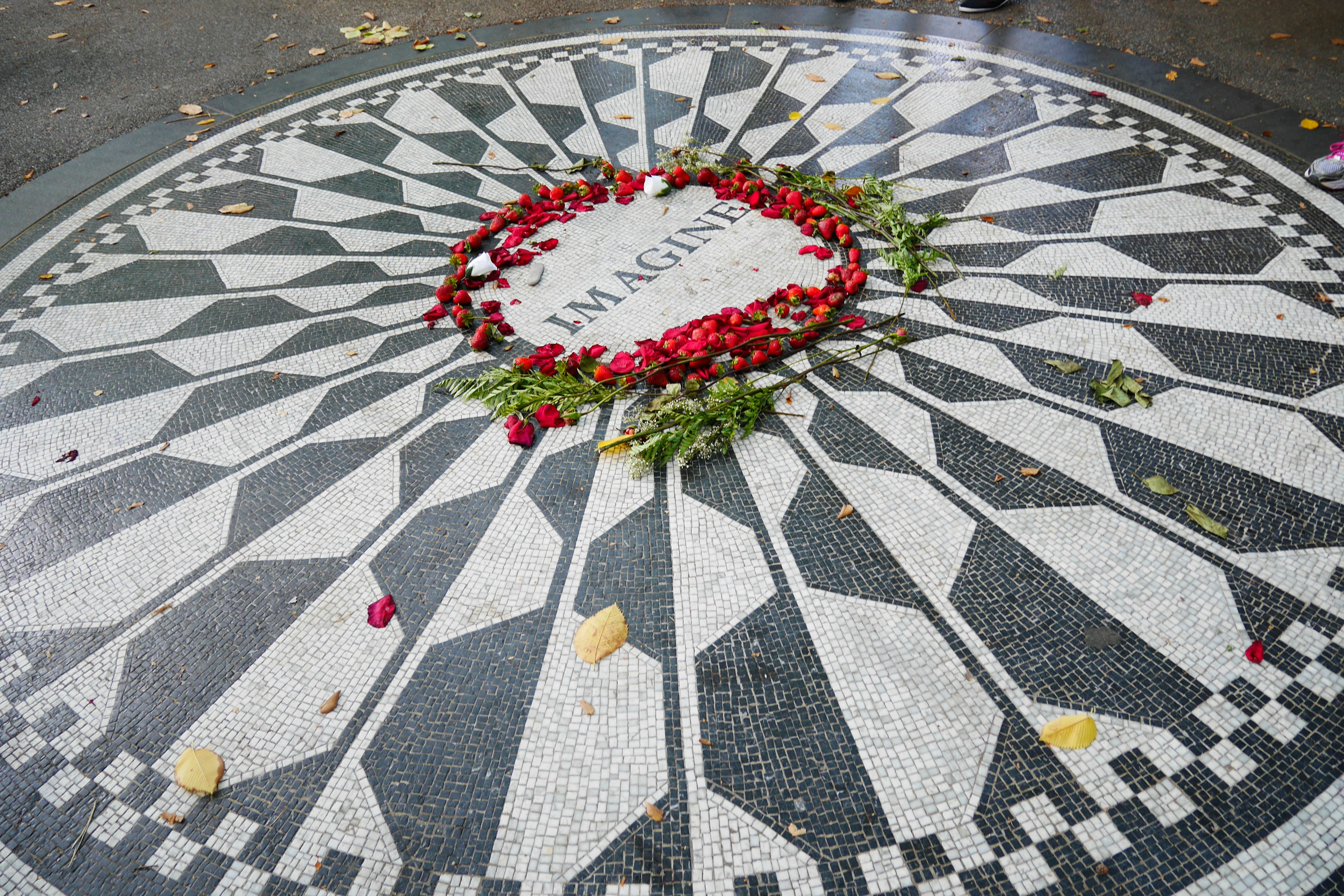 Immagine di un mosaico commemorativo con una corona floreale al centro