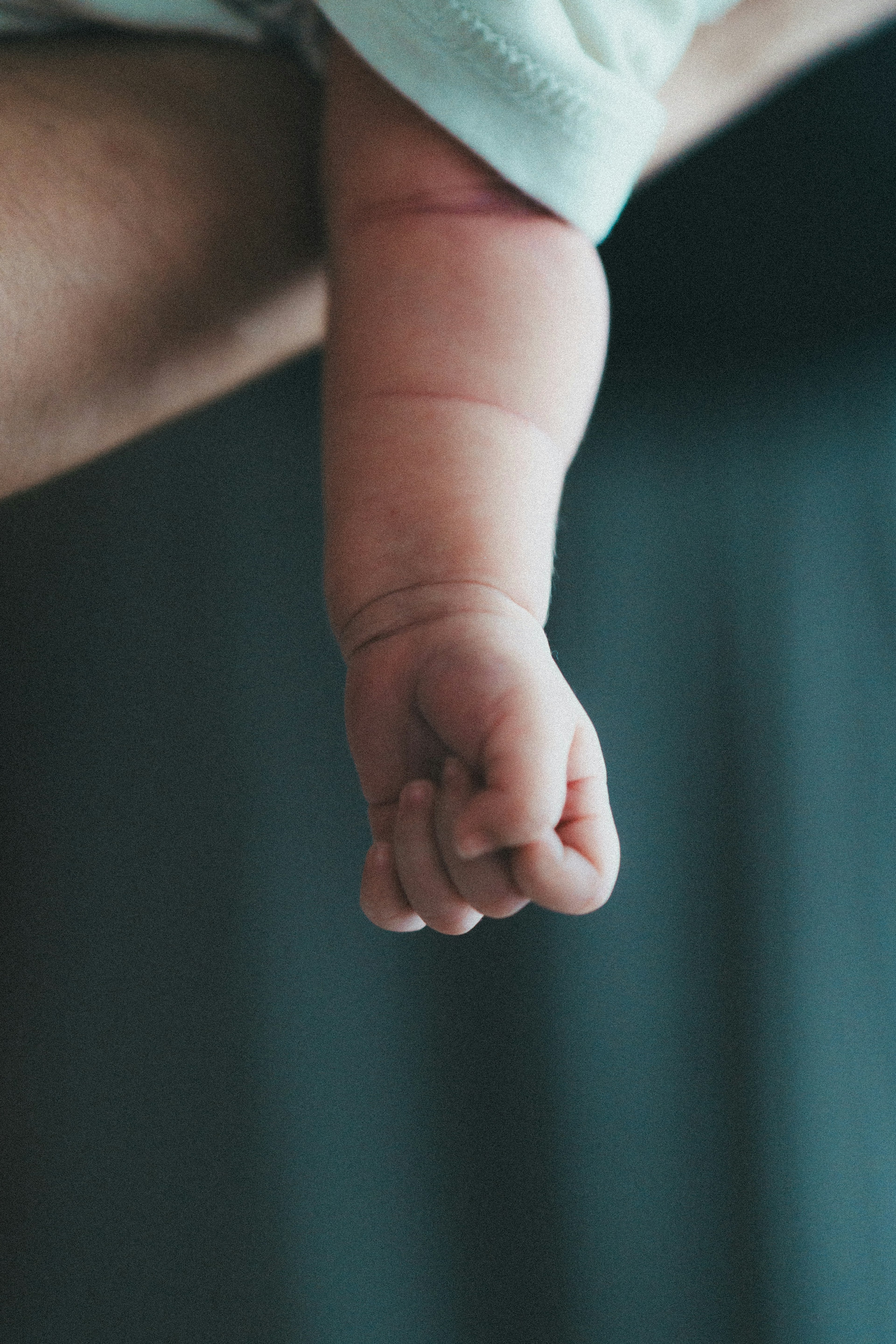 Nahaufnahme einer geschlossenen Faust eines Babys, die hängt