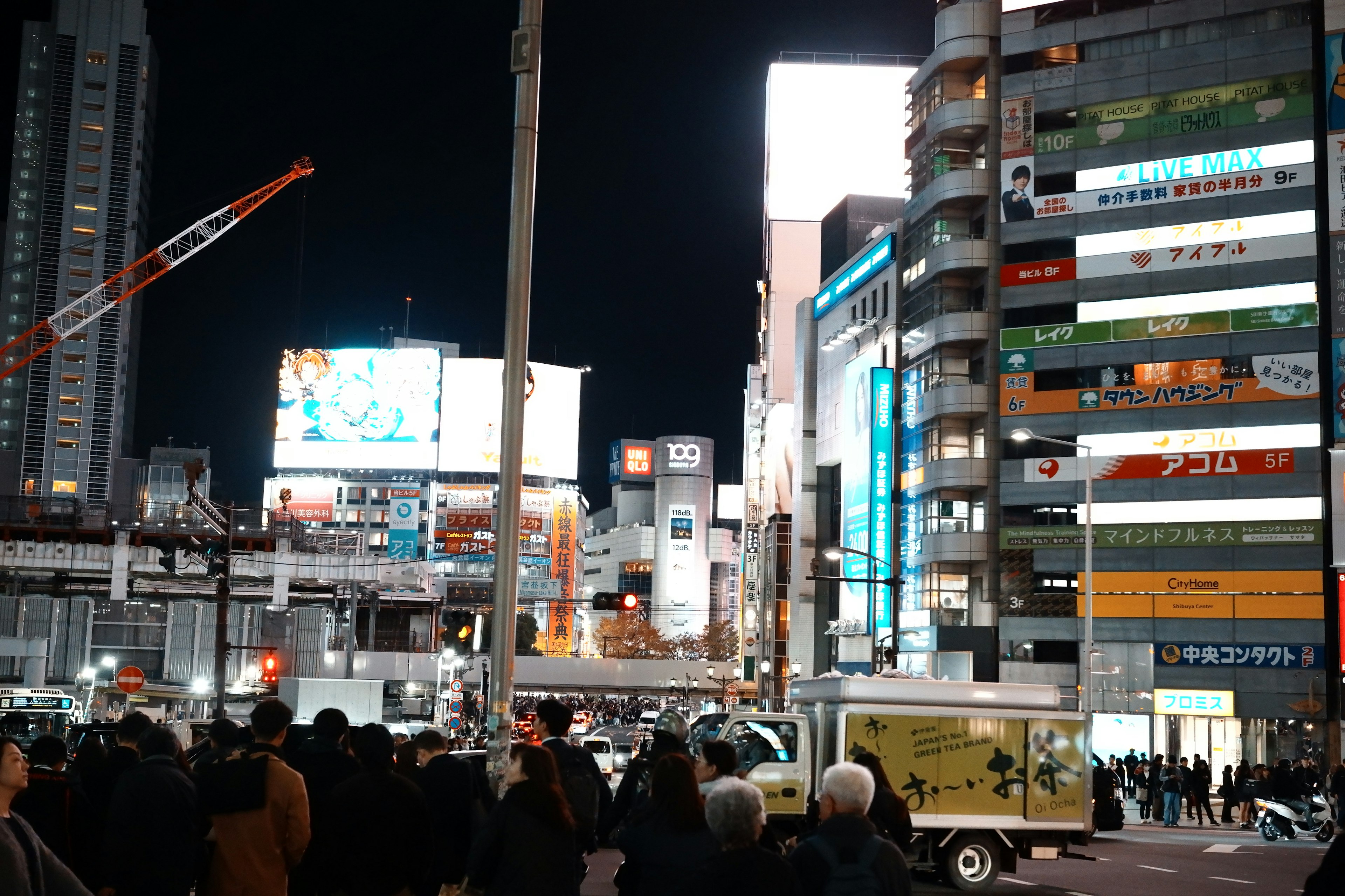 Escena urbana nocturna con carteles publicitarios brillantes en una zona concurrida