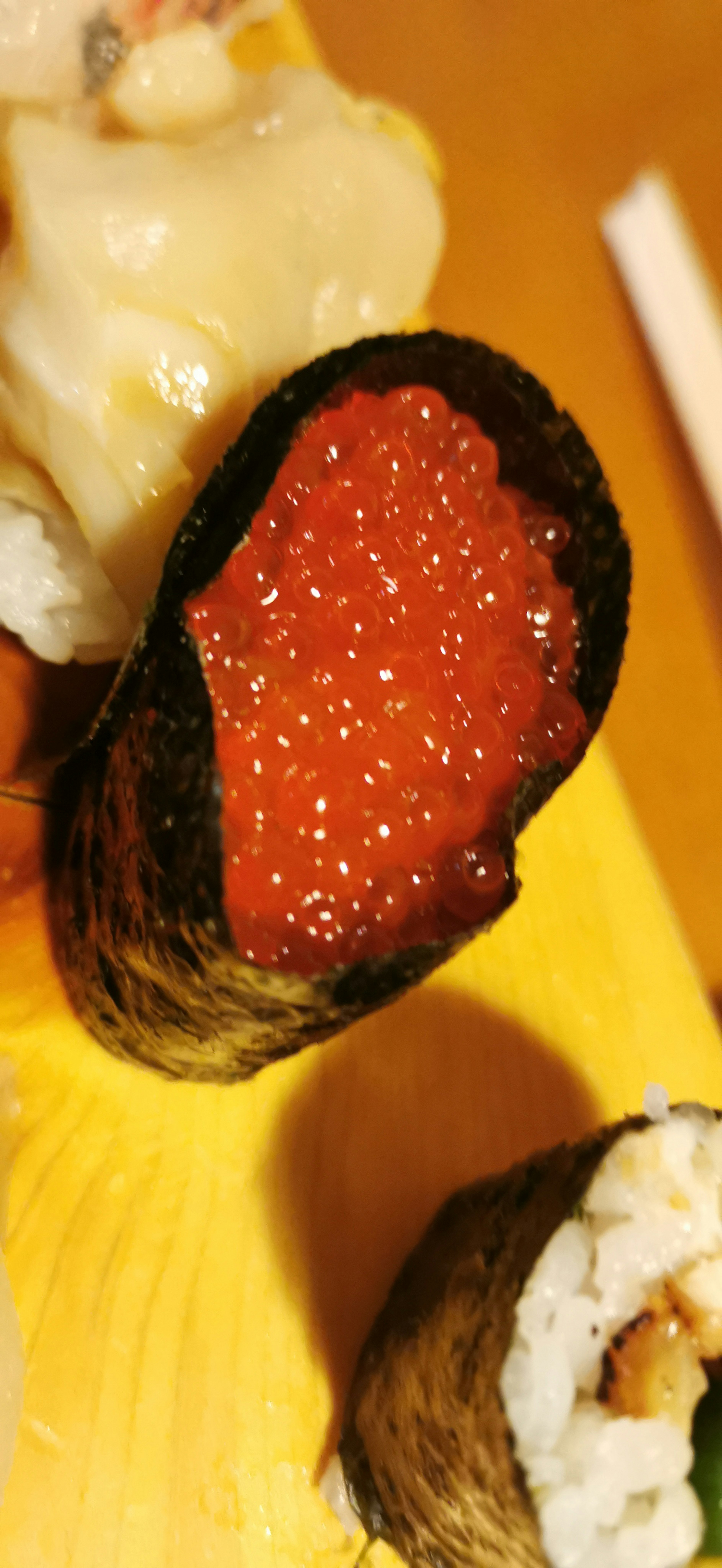 Foto close-up sushi gulung diisi telur ikan merah