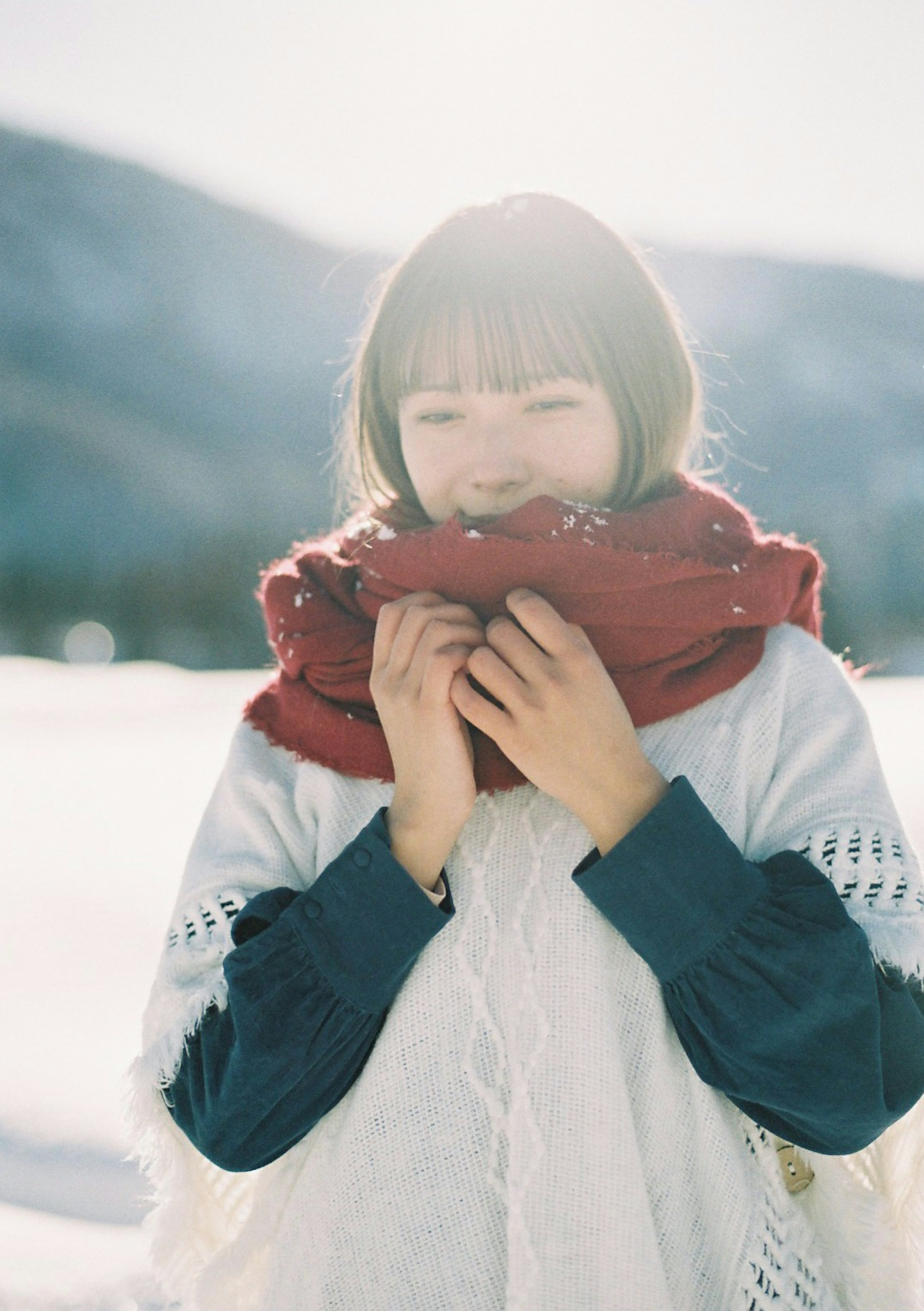 雪の中で赤いスカーフを持つ女性の笑顔