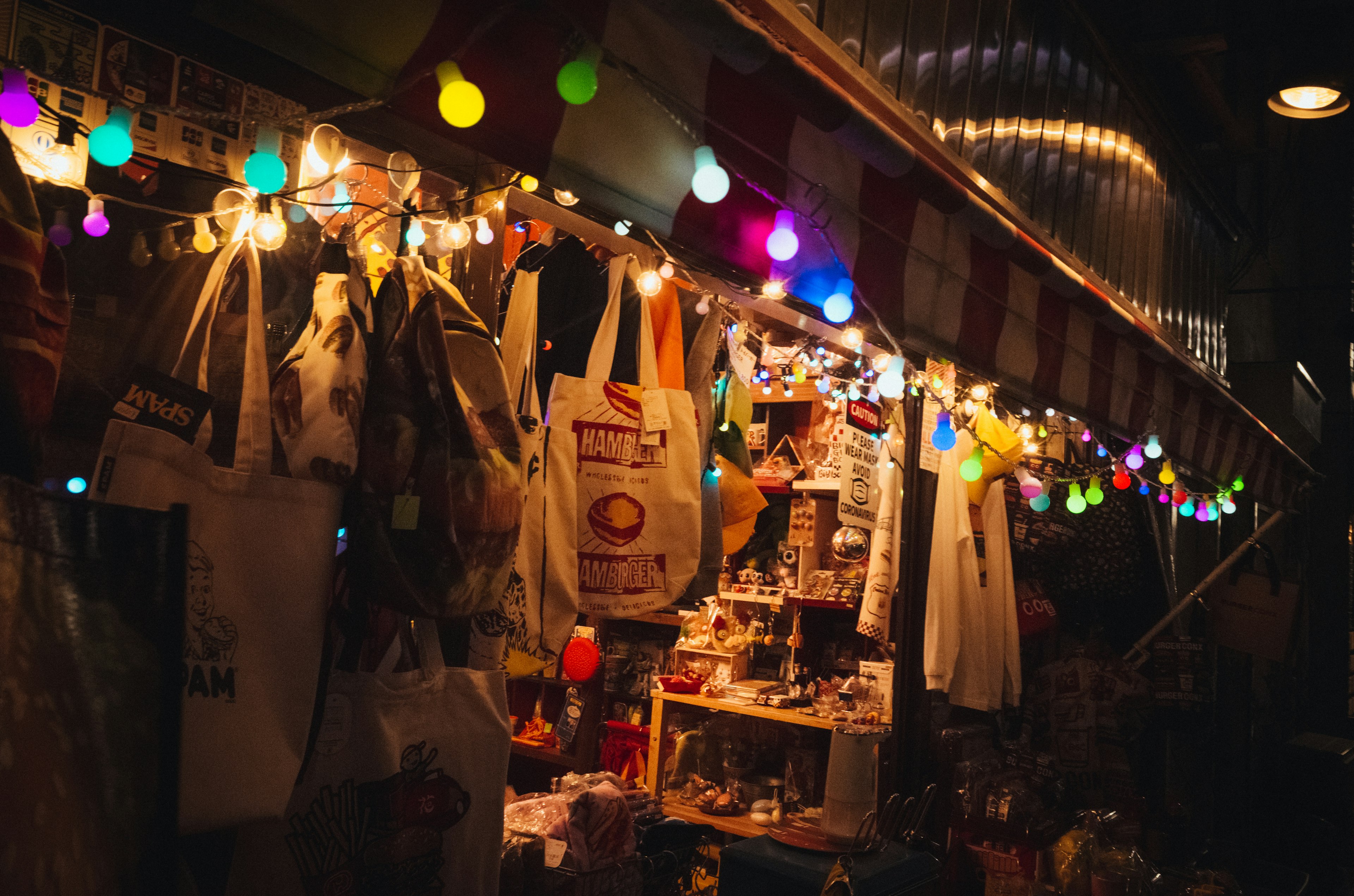 Vibrant night market scene with colorful lights and various items on display