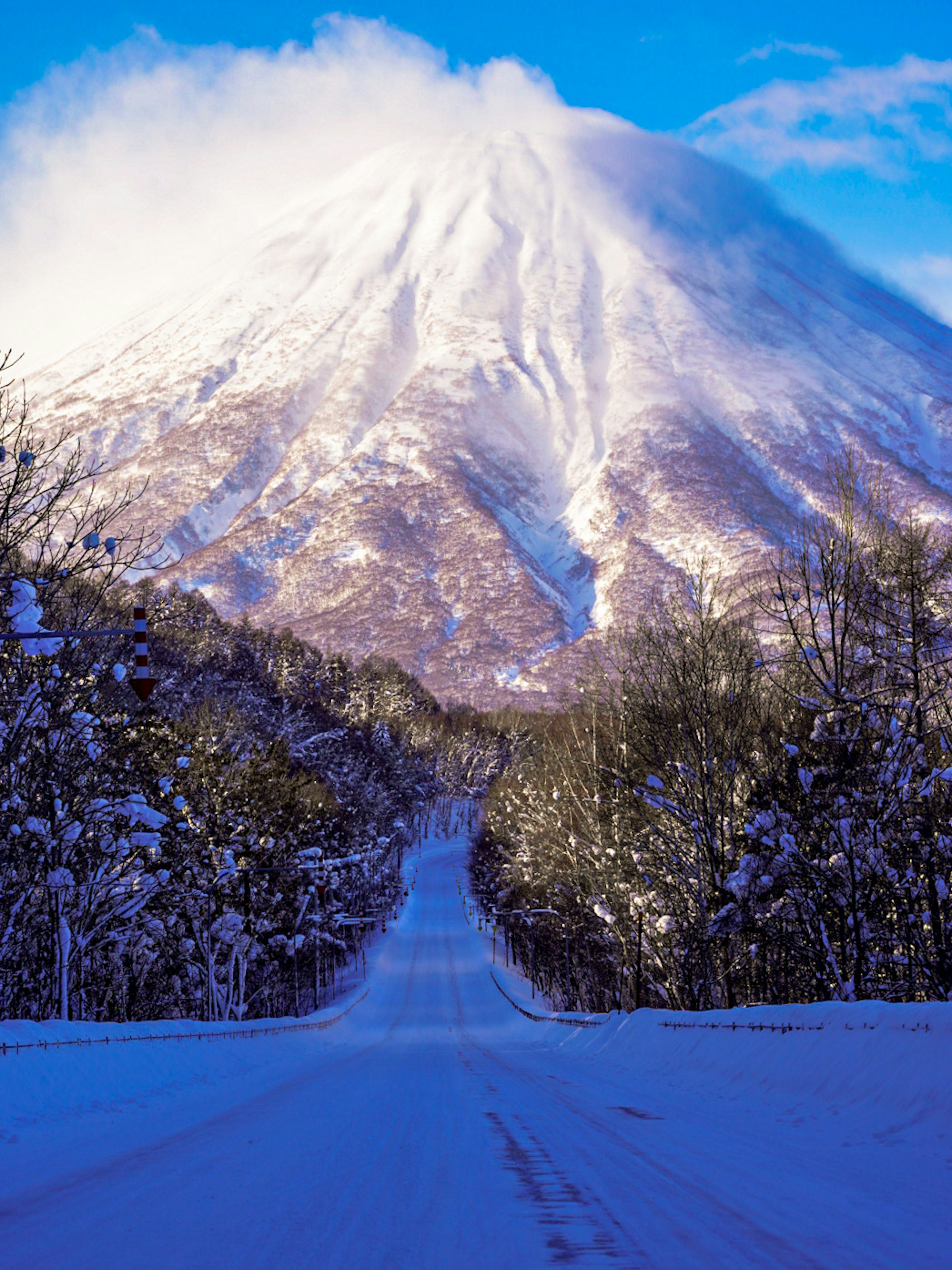 Camino cubierto de nieve que conduce a una majestuosa montaña