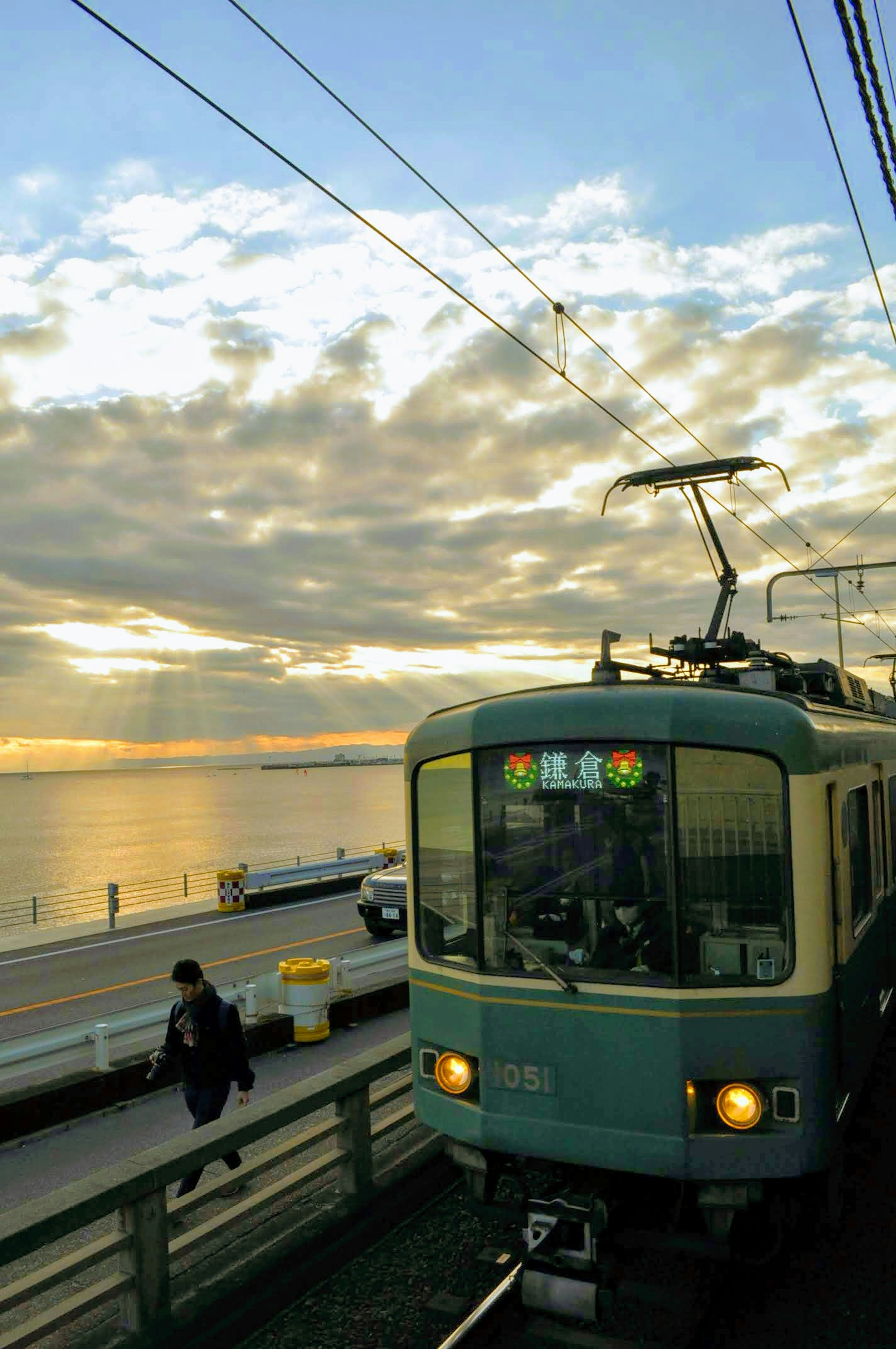 Train stopped near the sea illuminated by sunset with a person