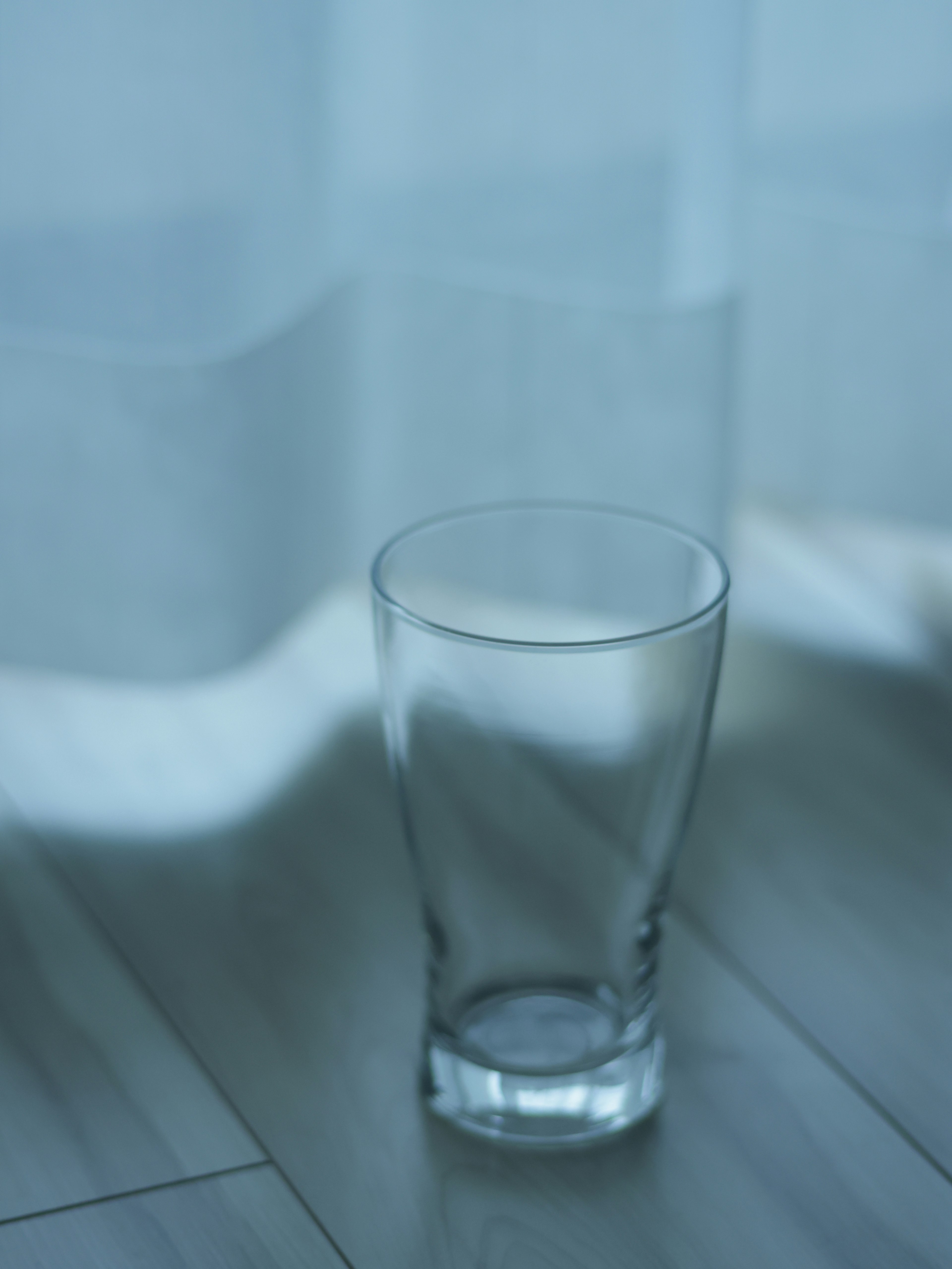 A clear glass placed near a window with soft light