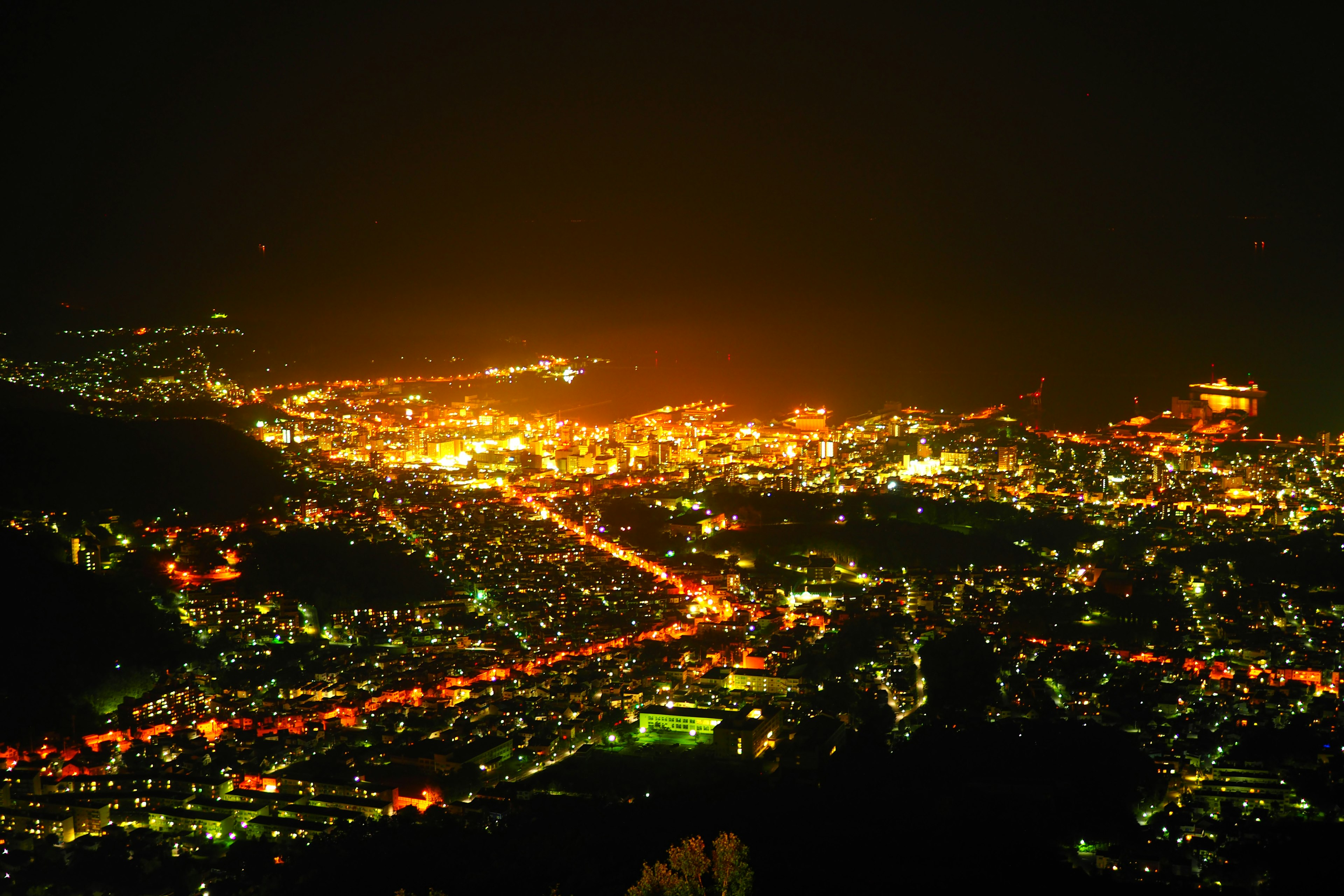 Vista notturna di una città illuminata da lampioni e strade