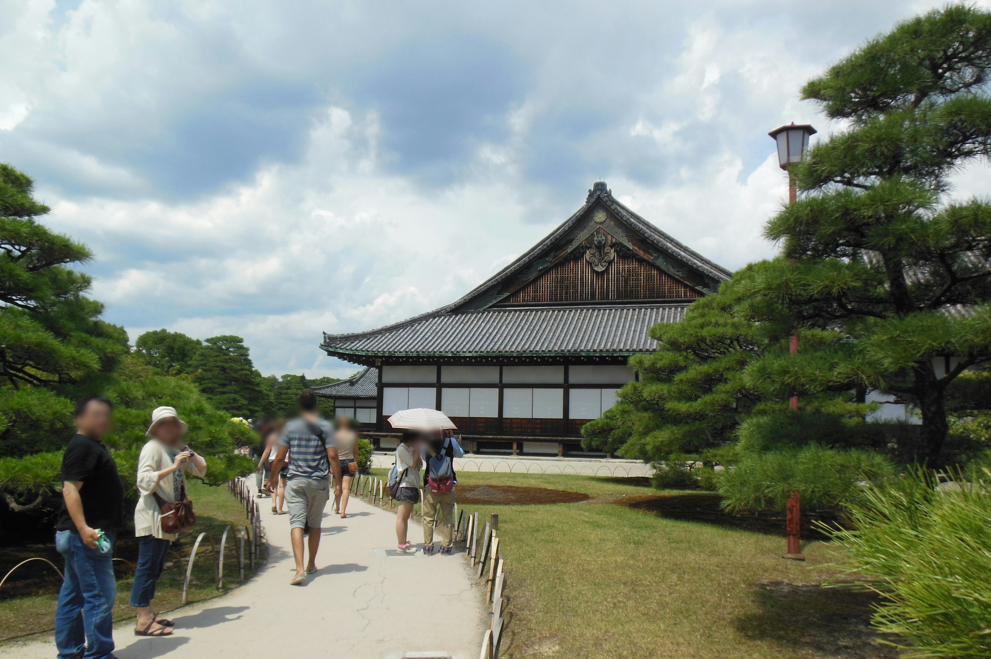 Besucher, die in einem schönen japanischen Garten mit einem traditionellen Gebäude spazieren