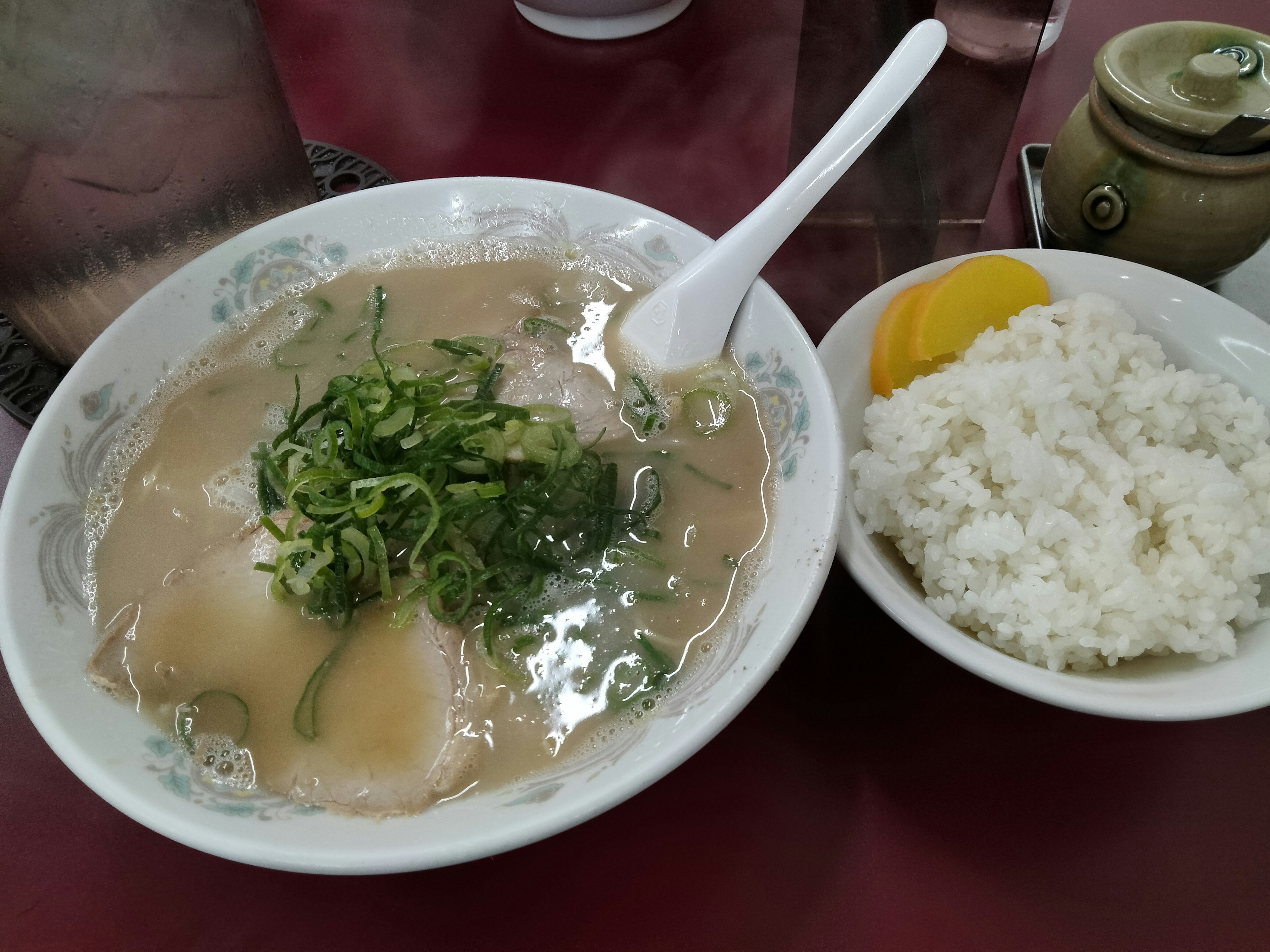 Schüssel mit Suppe und Frühlingszwiebel, serviert mit Reis