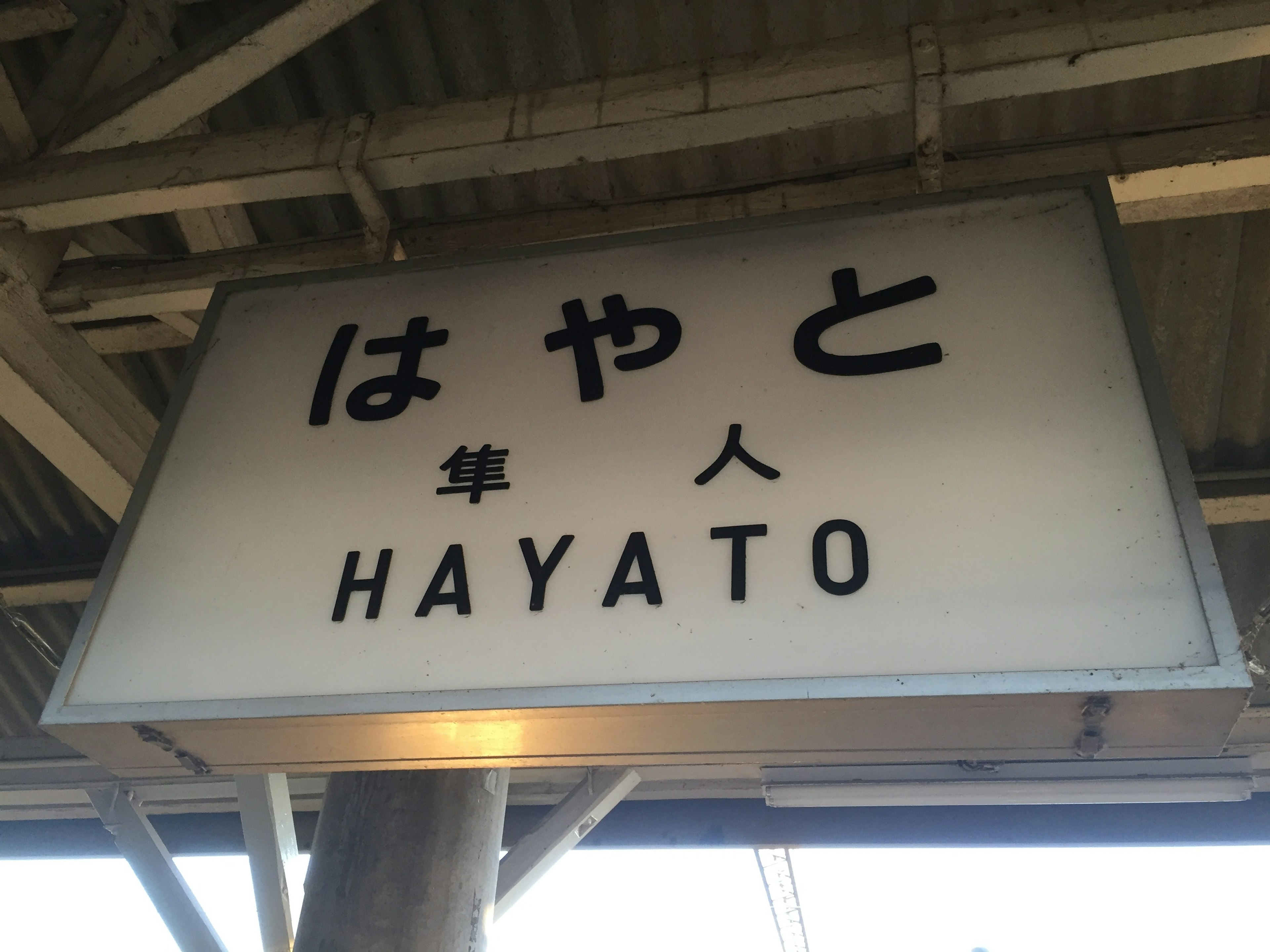 Signboard of Hayato Station displaying Japanese and English text