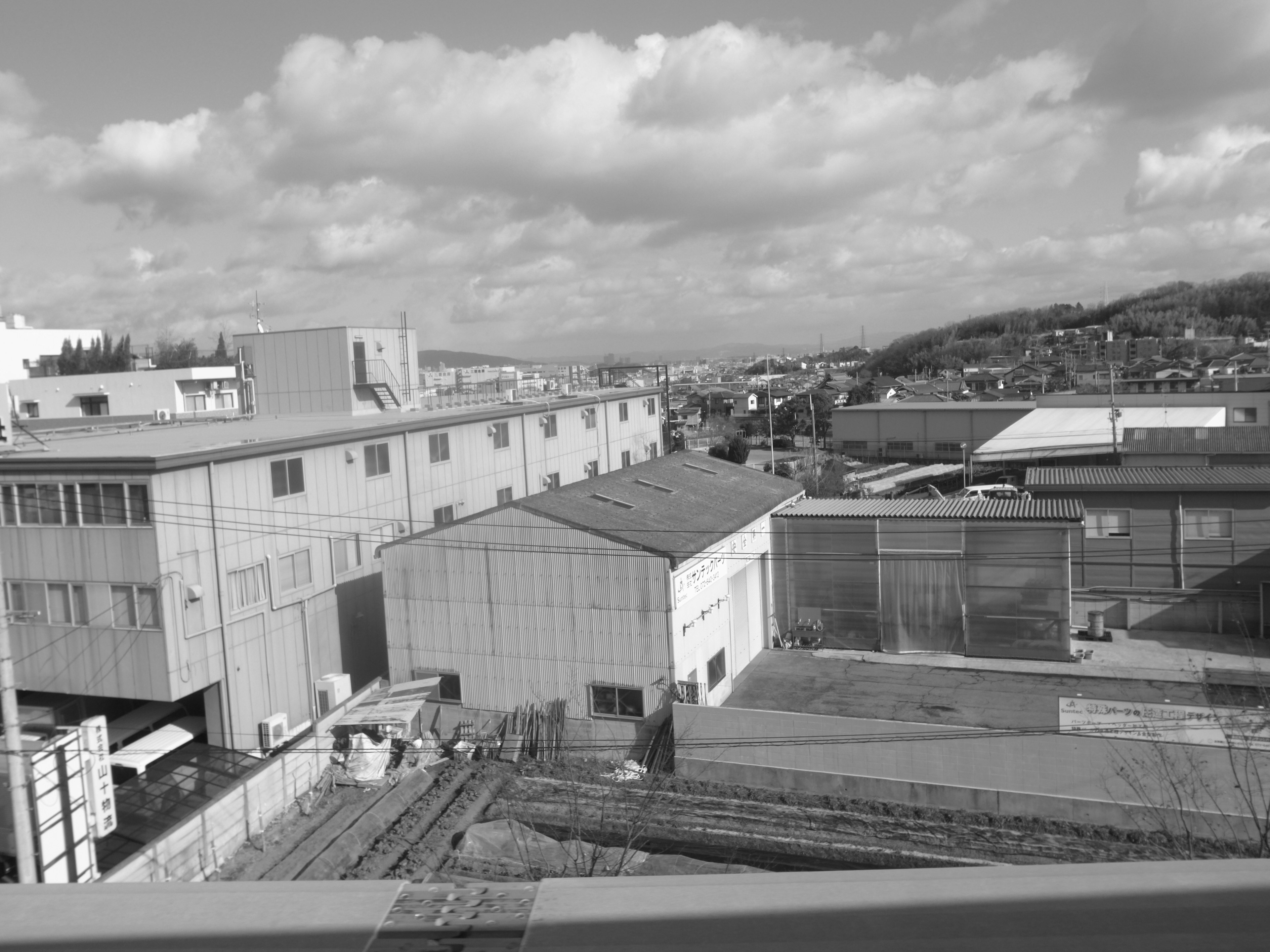 Vista da un tetto di fabbrica che mostra un mix di edifici residenziali e industriali