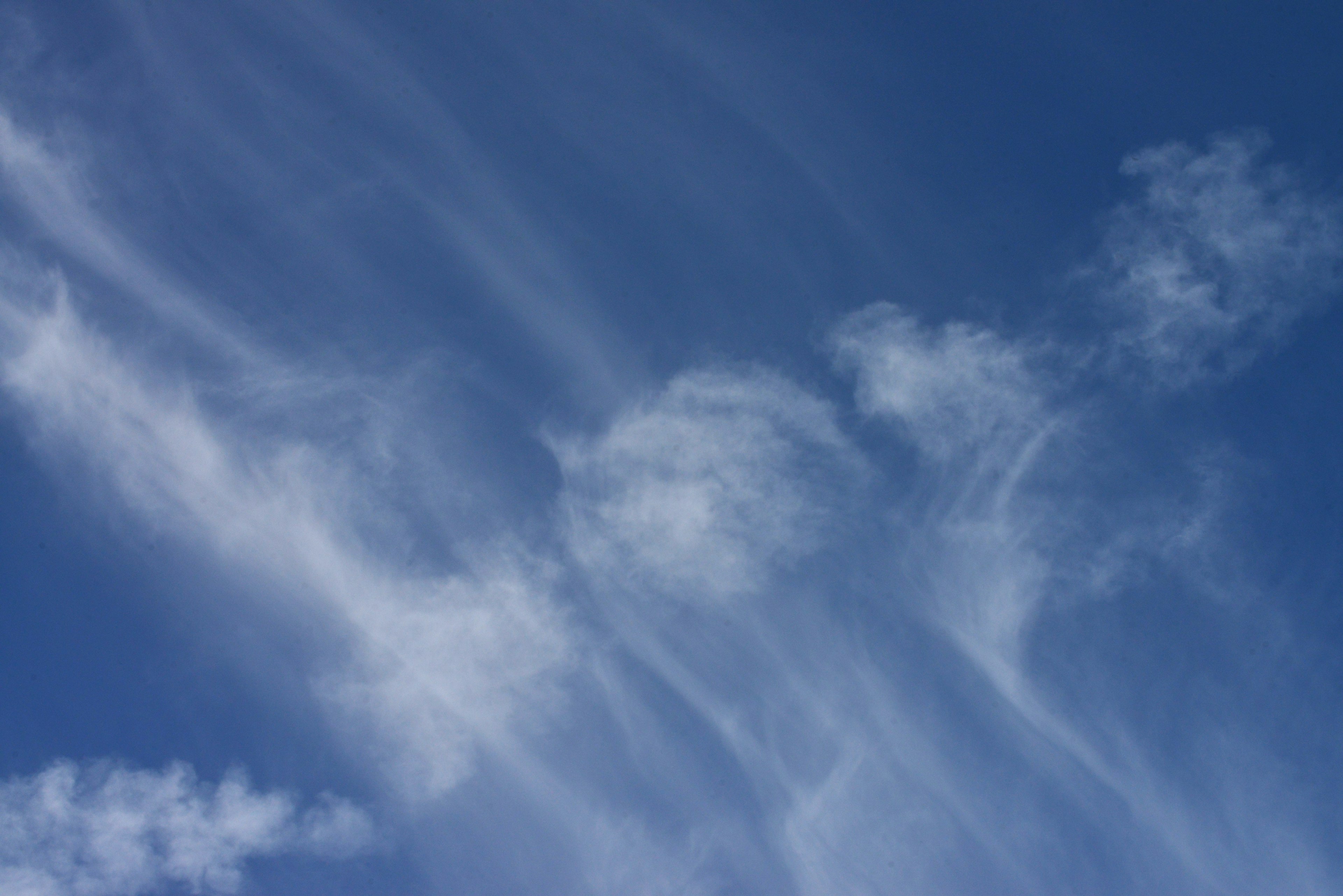 Flowing white clouds against a bright blue sky