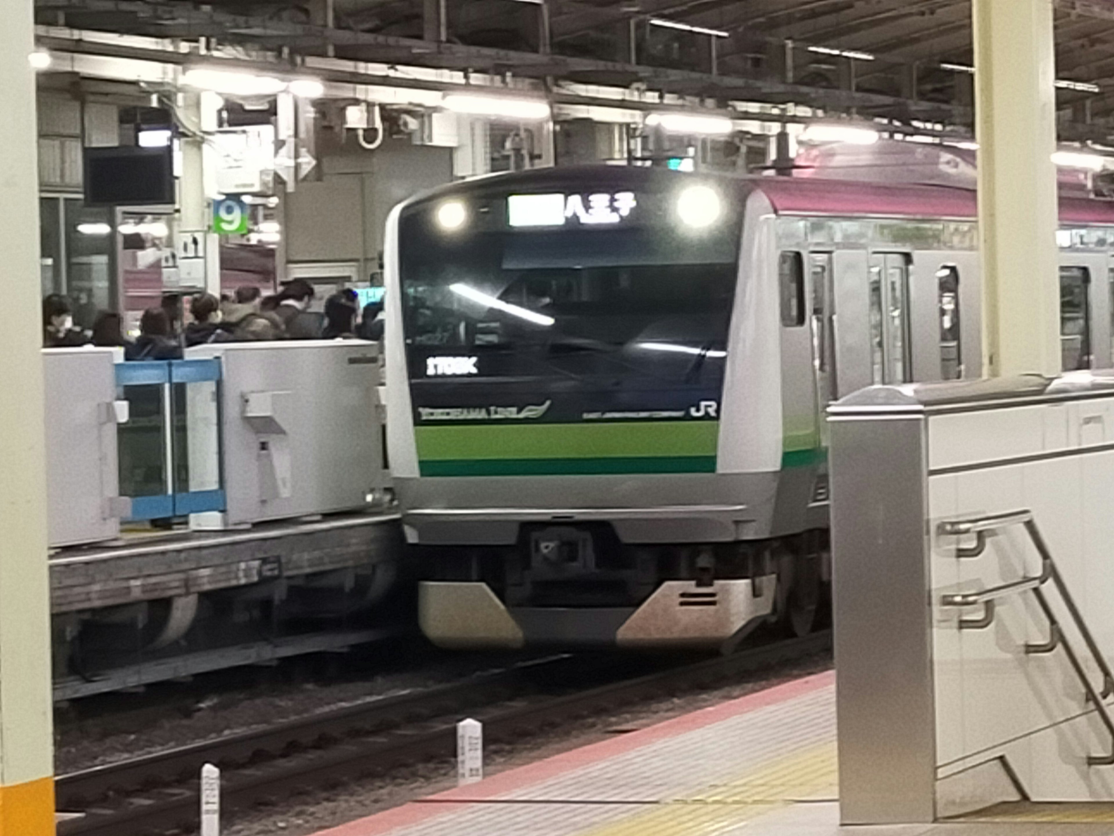 รถไฟสีเขียวและสีดำจอดที่สถานีมีผู้โดยสารจำนวนมาก