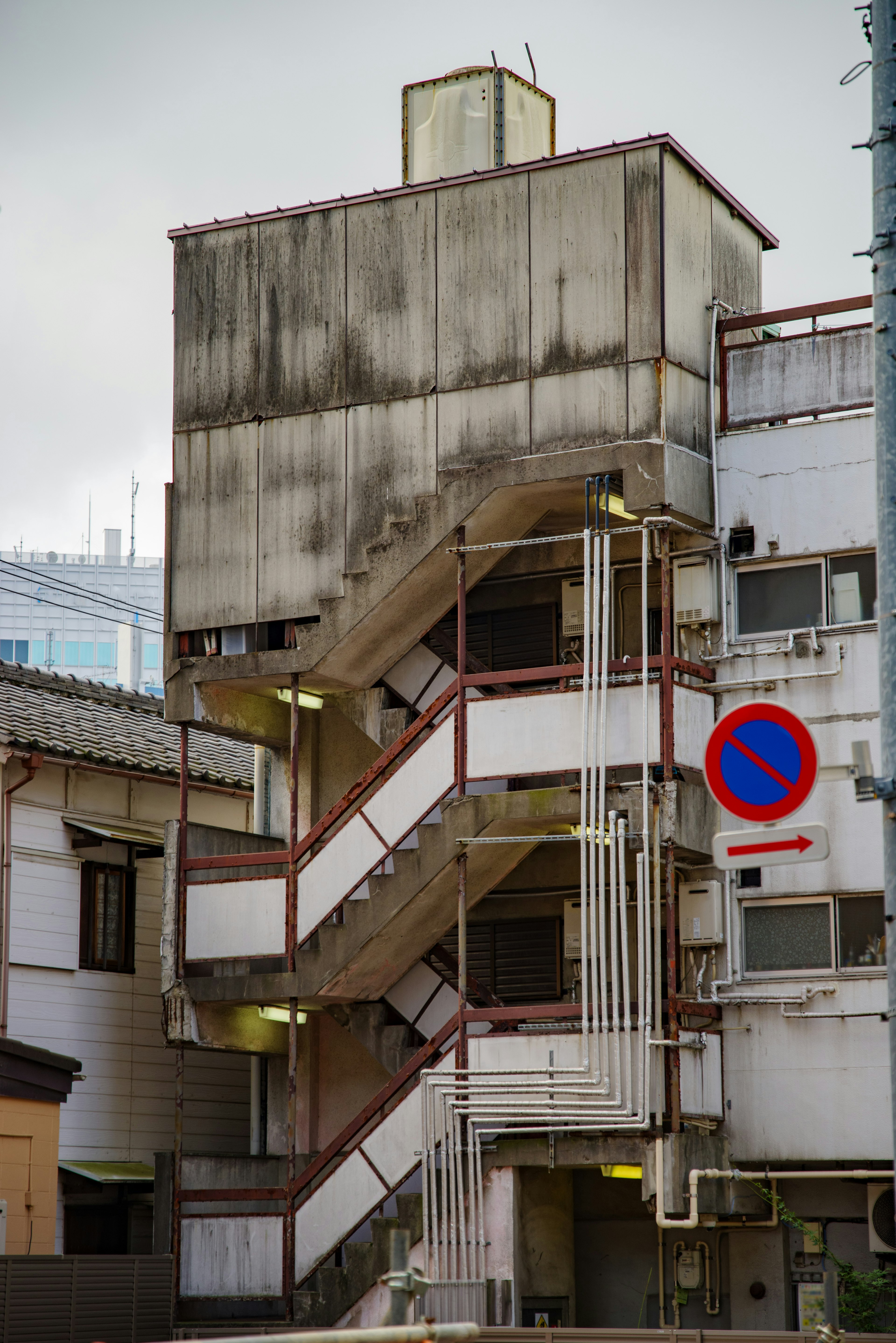 Urban scene featuring an old building with external stairs and weathered walls