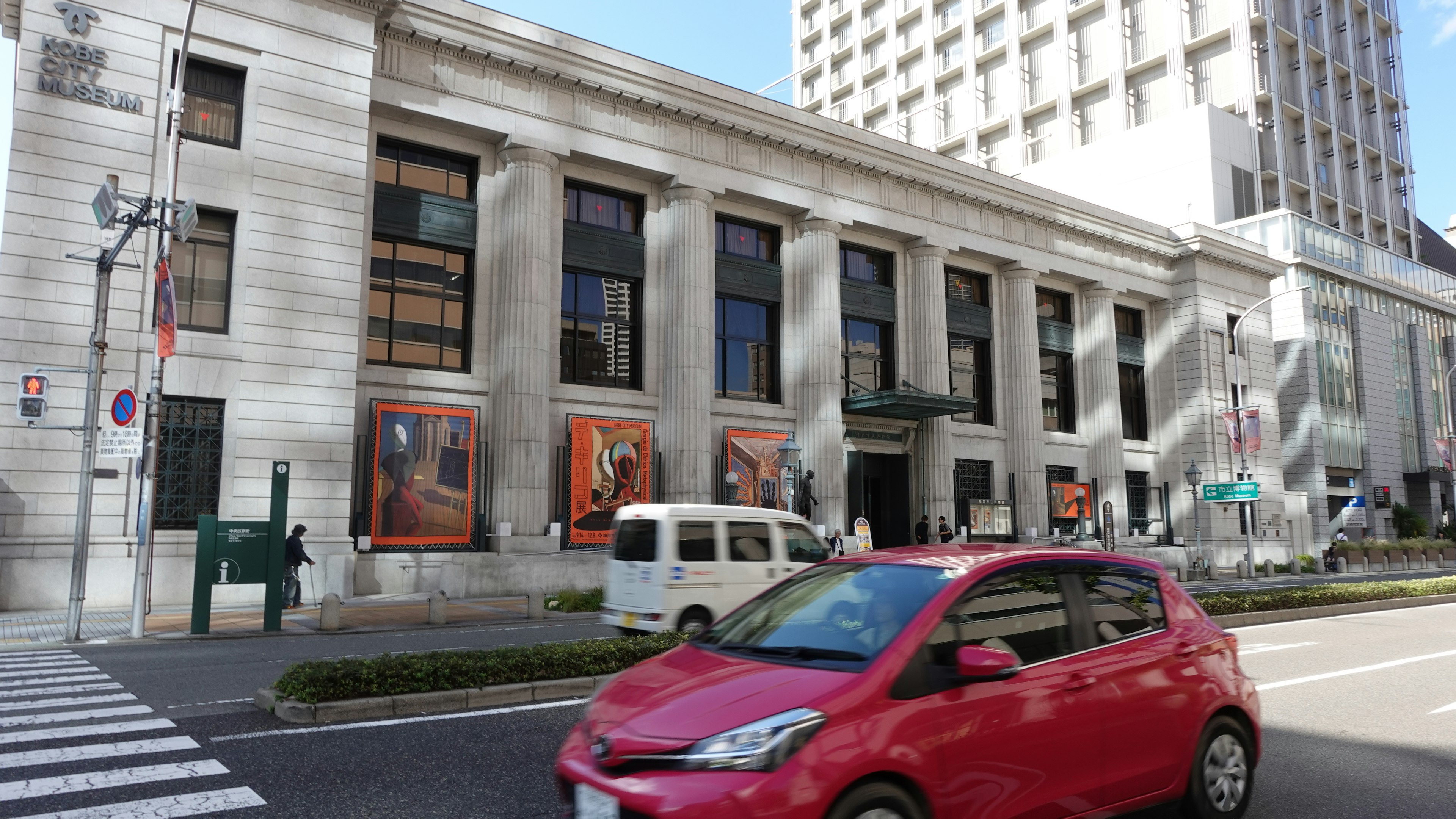 赤い車と歴史的な建物の外観が見える街の風景