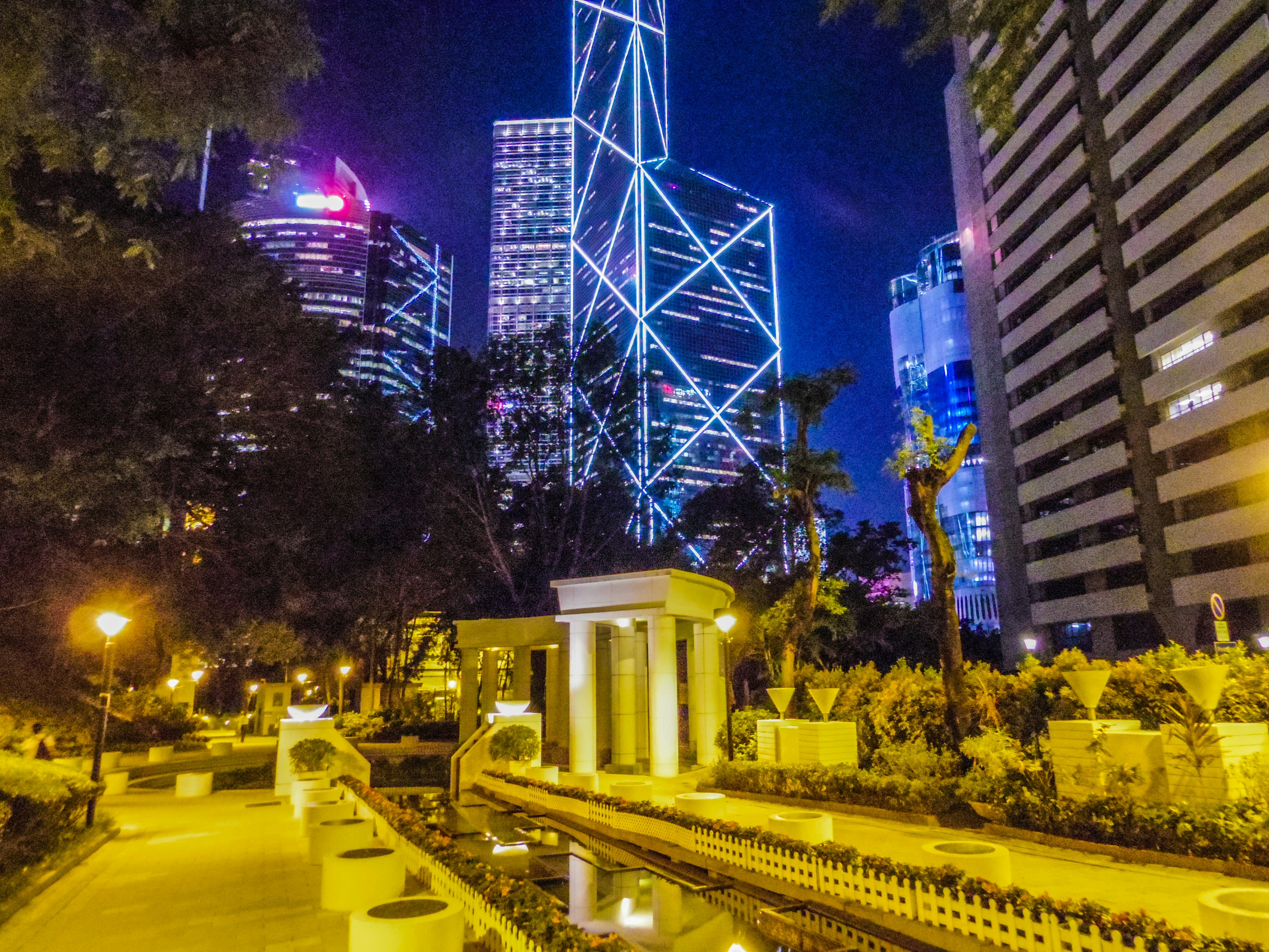 Night view of Hong Kong skyline with illuminated pathways and water features