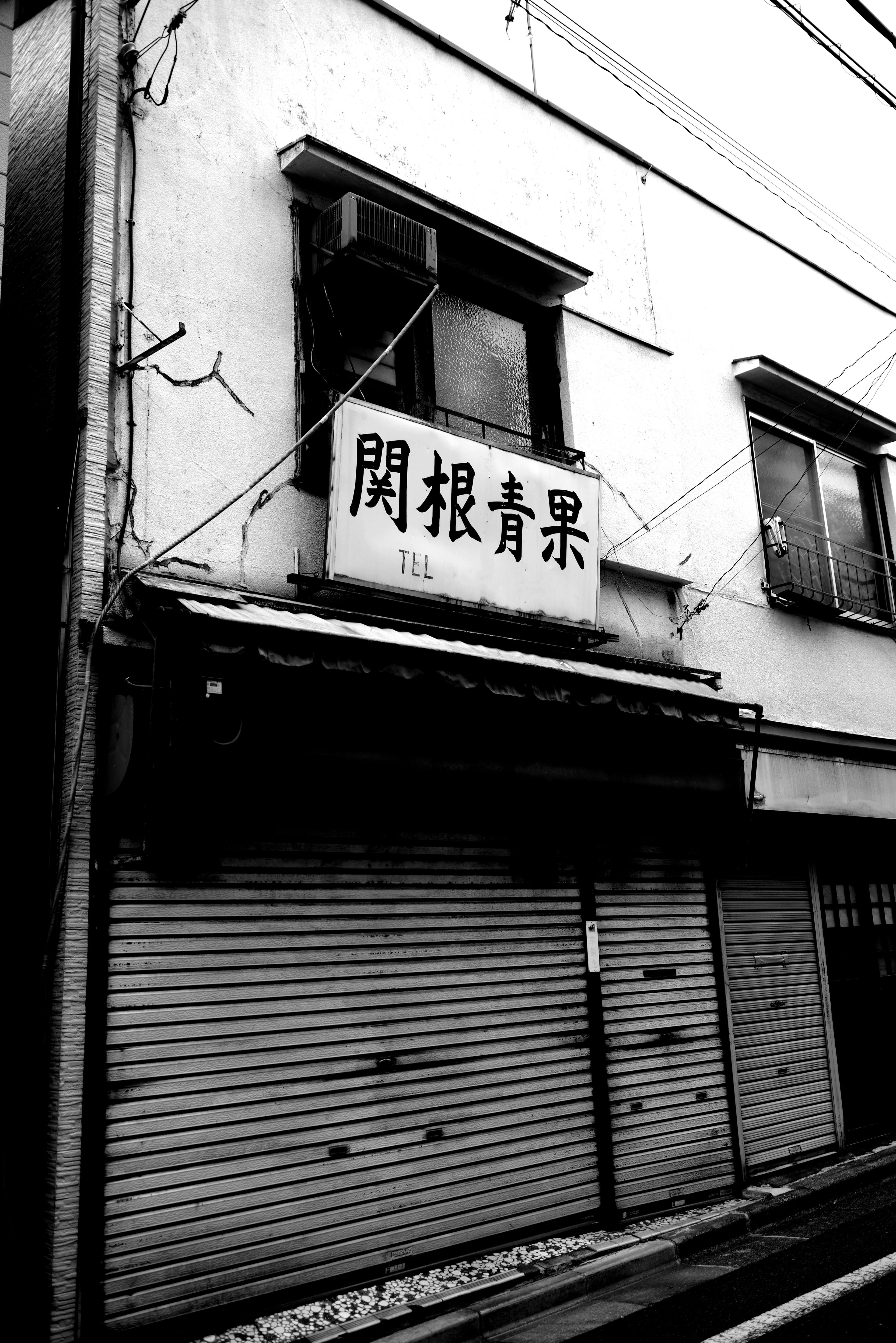 Exterior of an old shop with a fruit sign