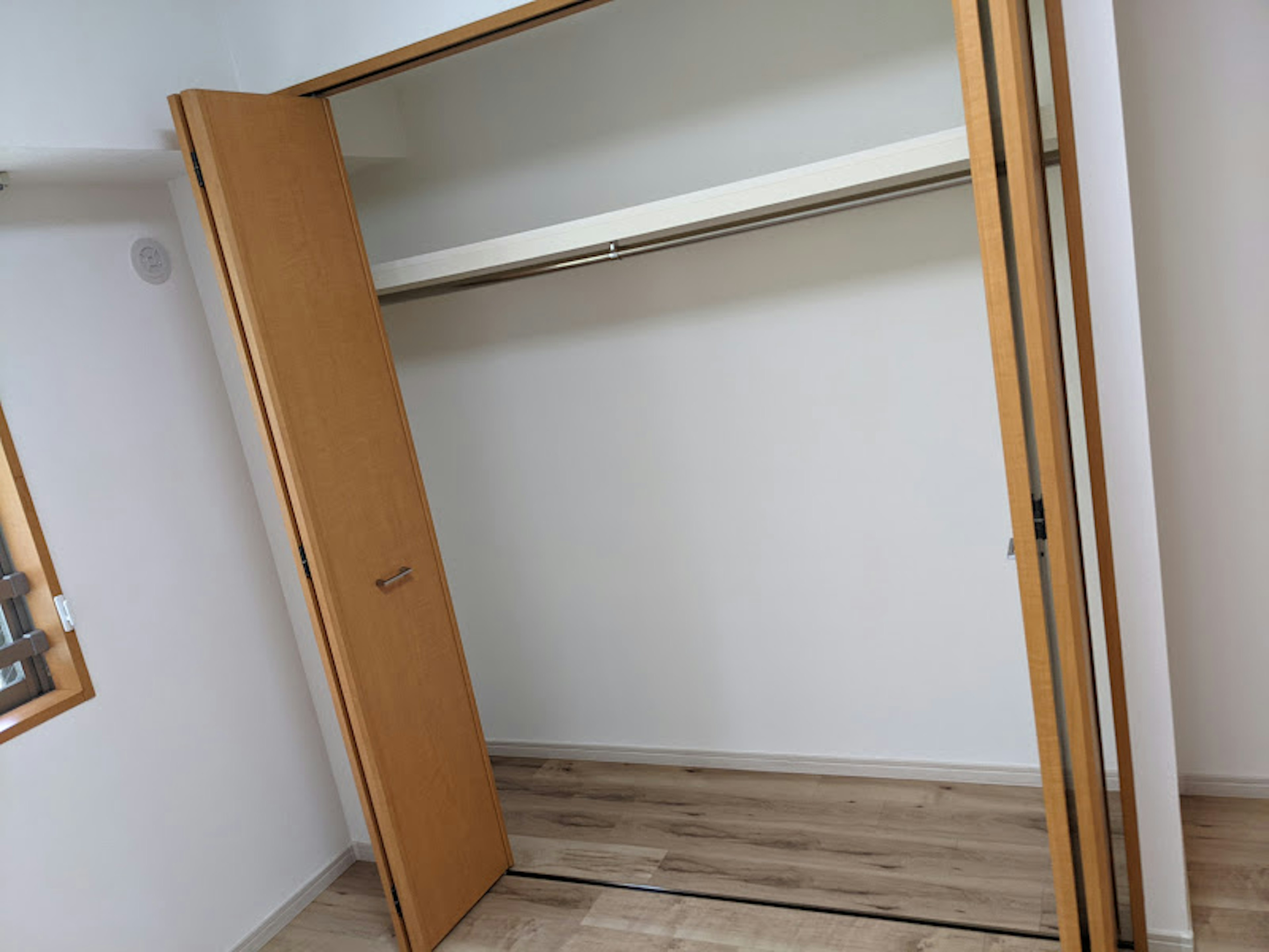 Leerer Kleiderschrank mit sichtbarem Holzboden in einem Raum