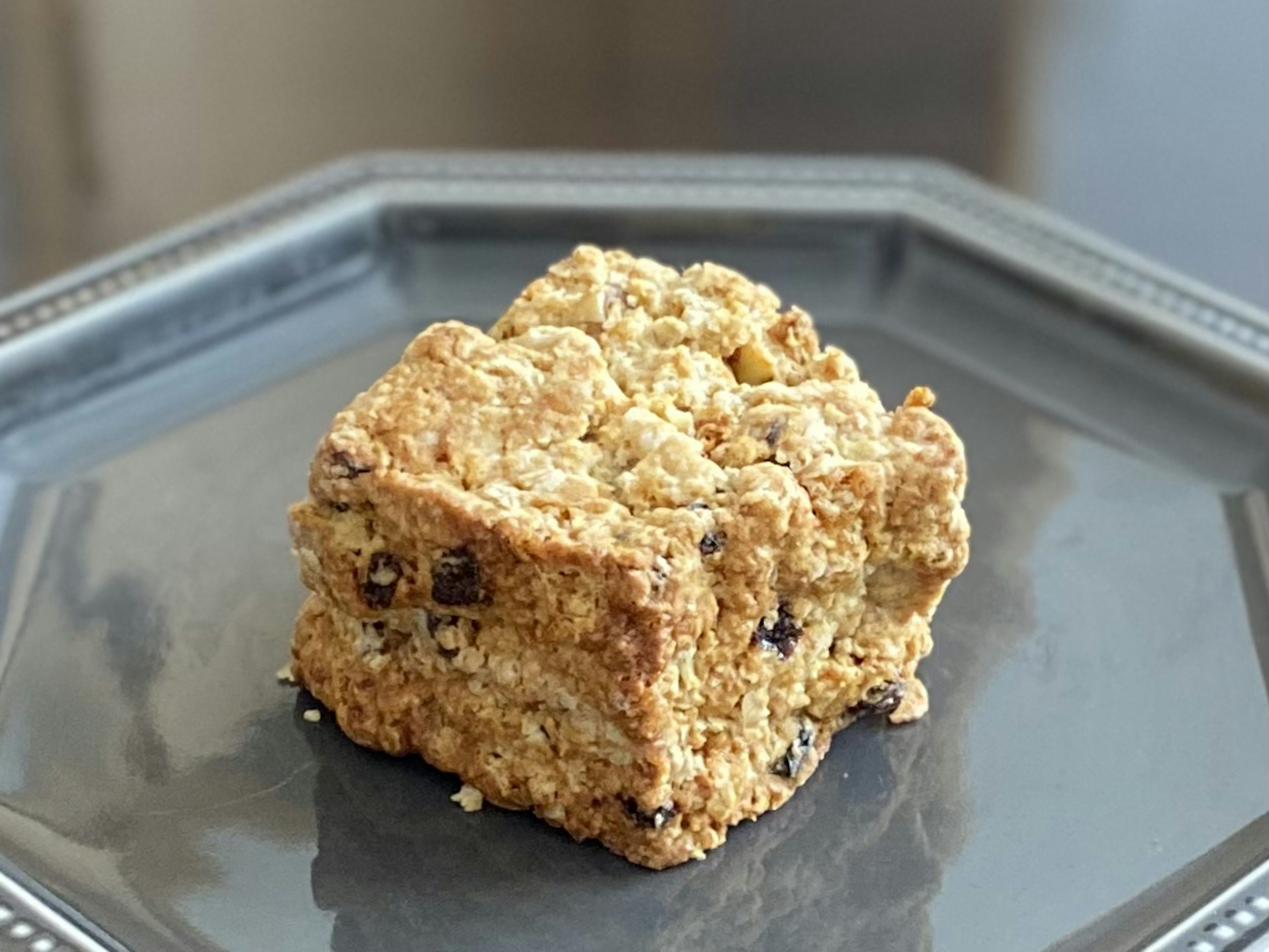 Un scone carré avec des pépites de chocolat sur une assiette noire