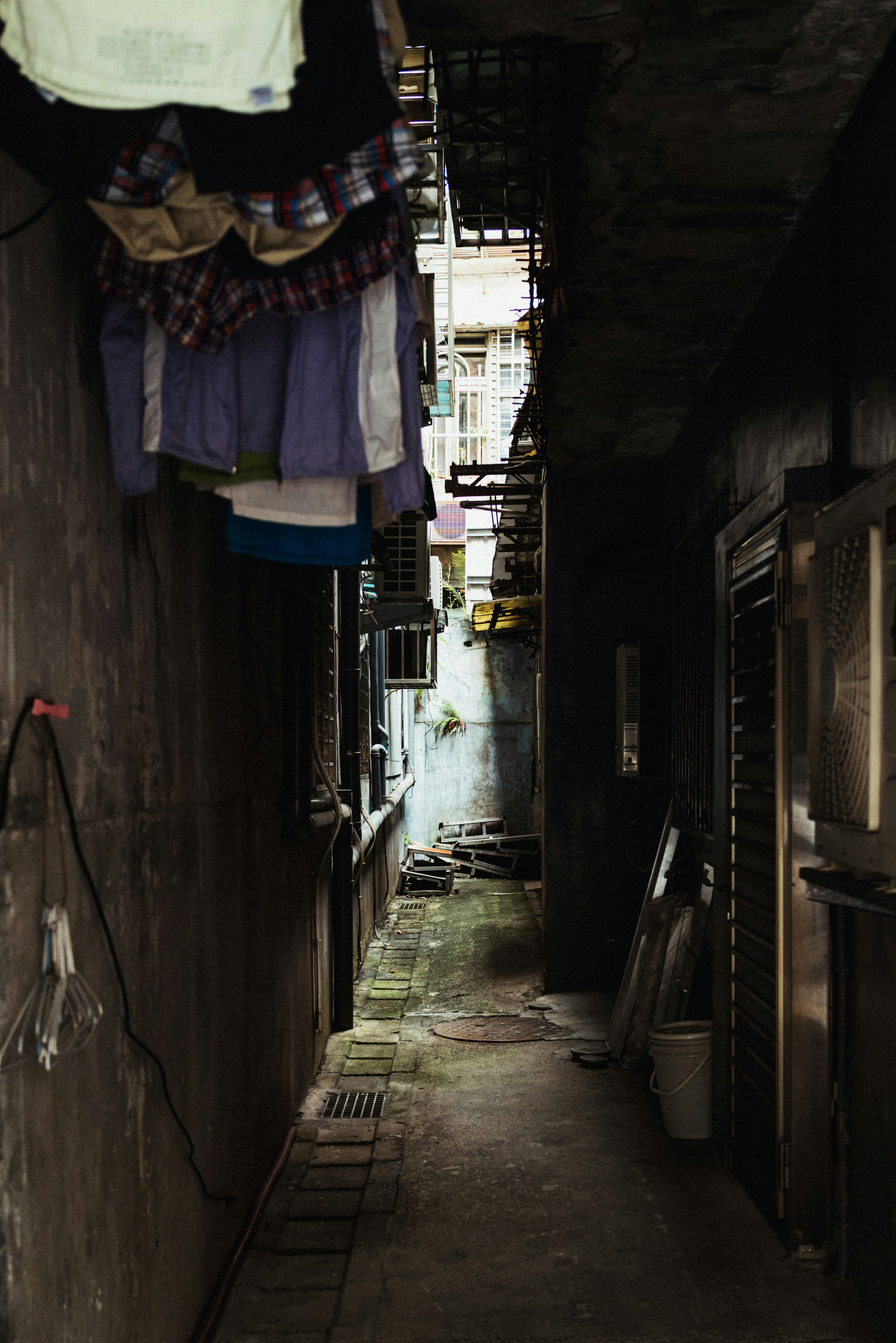 Narrow alley with hanging clothes and dark walls