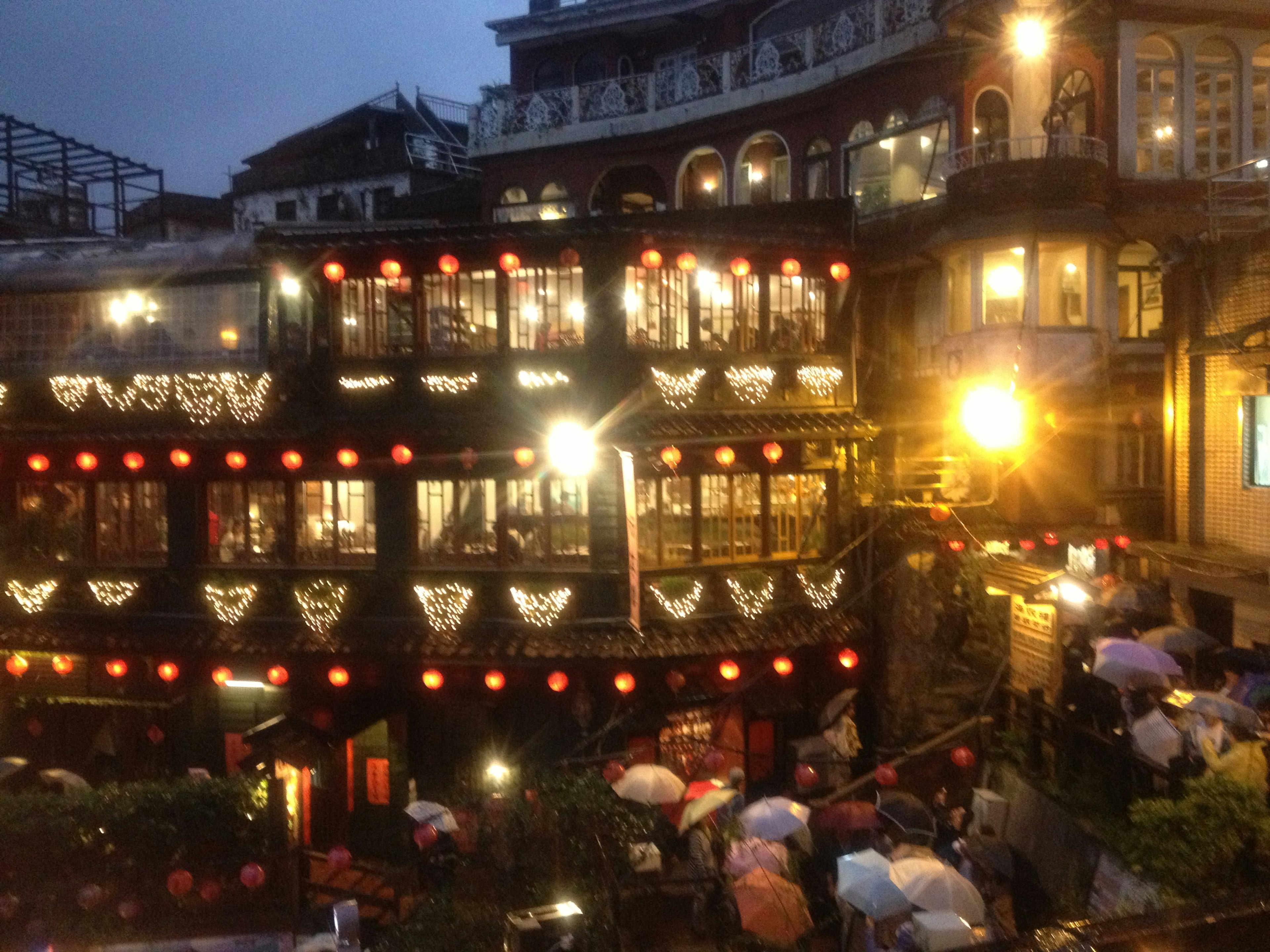 Traditional building illuminated at night with decorative lights in a bustling street