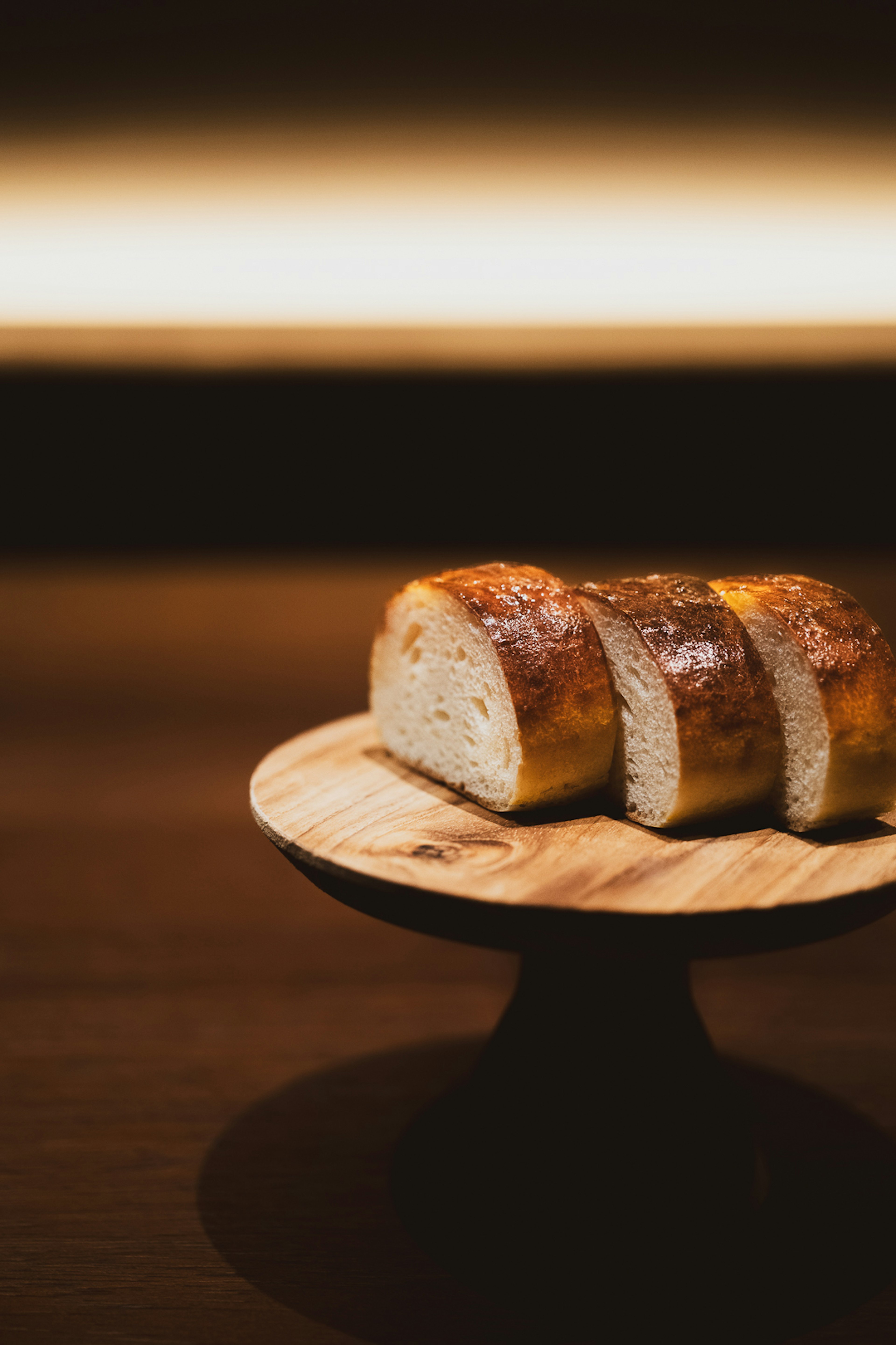 Roti iris dengan kerak keemasan di atas piring kayu