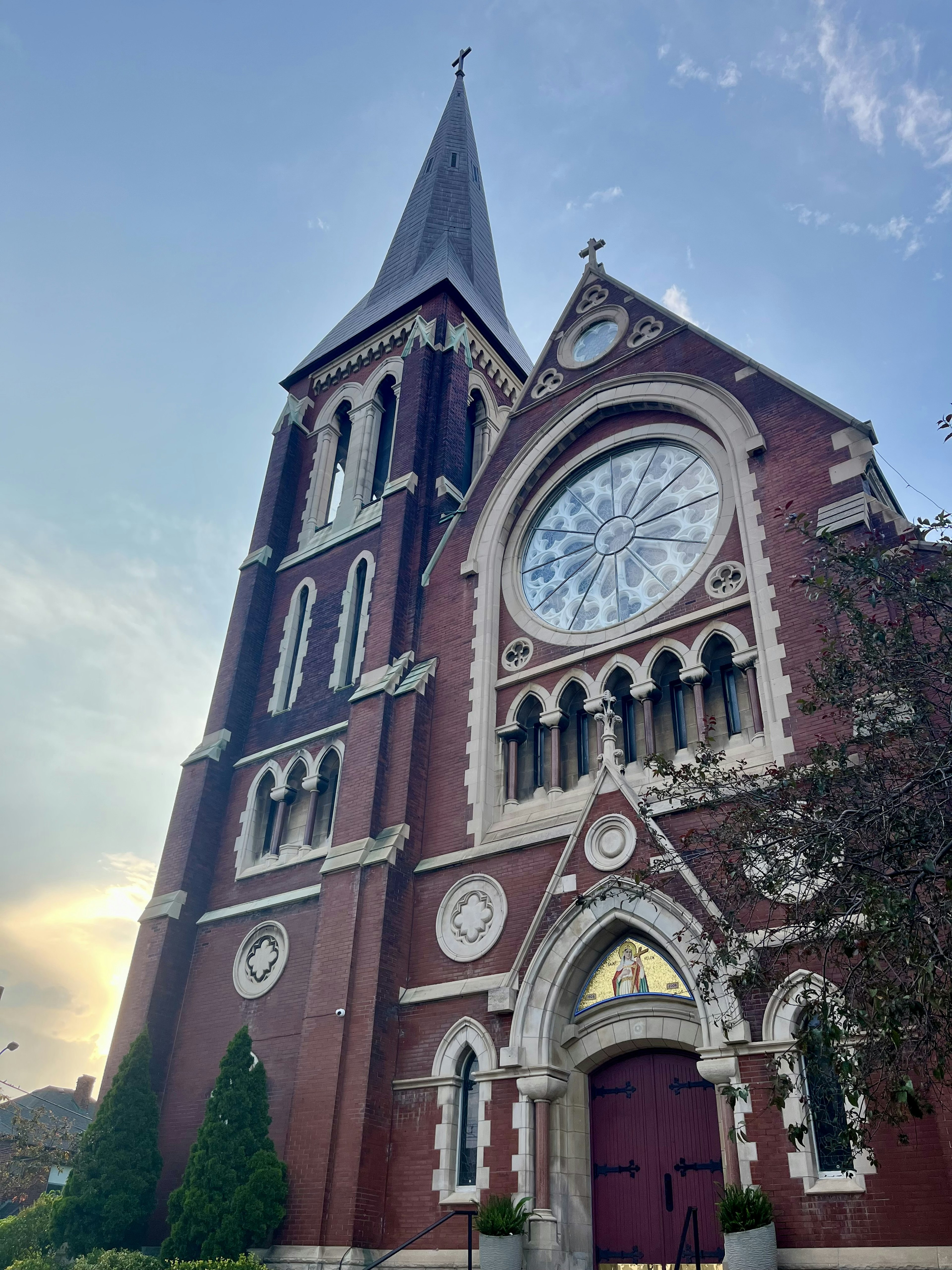 Extérieur d'une église en brique rouge avec une fenêtre en vitrail